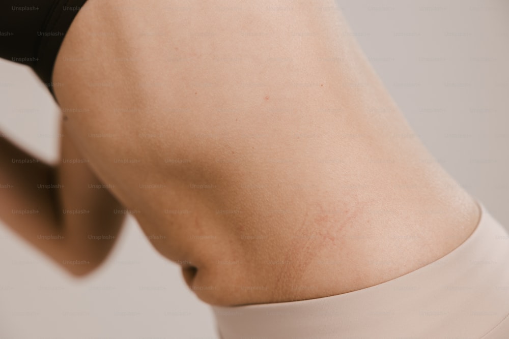 a close up of a woman's back with a cell phone in her hand