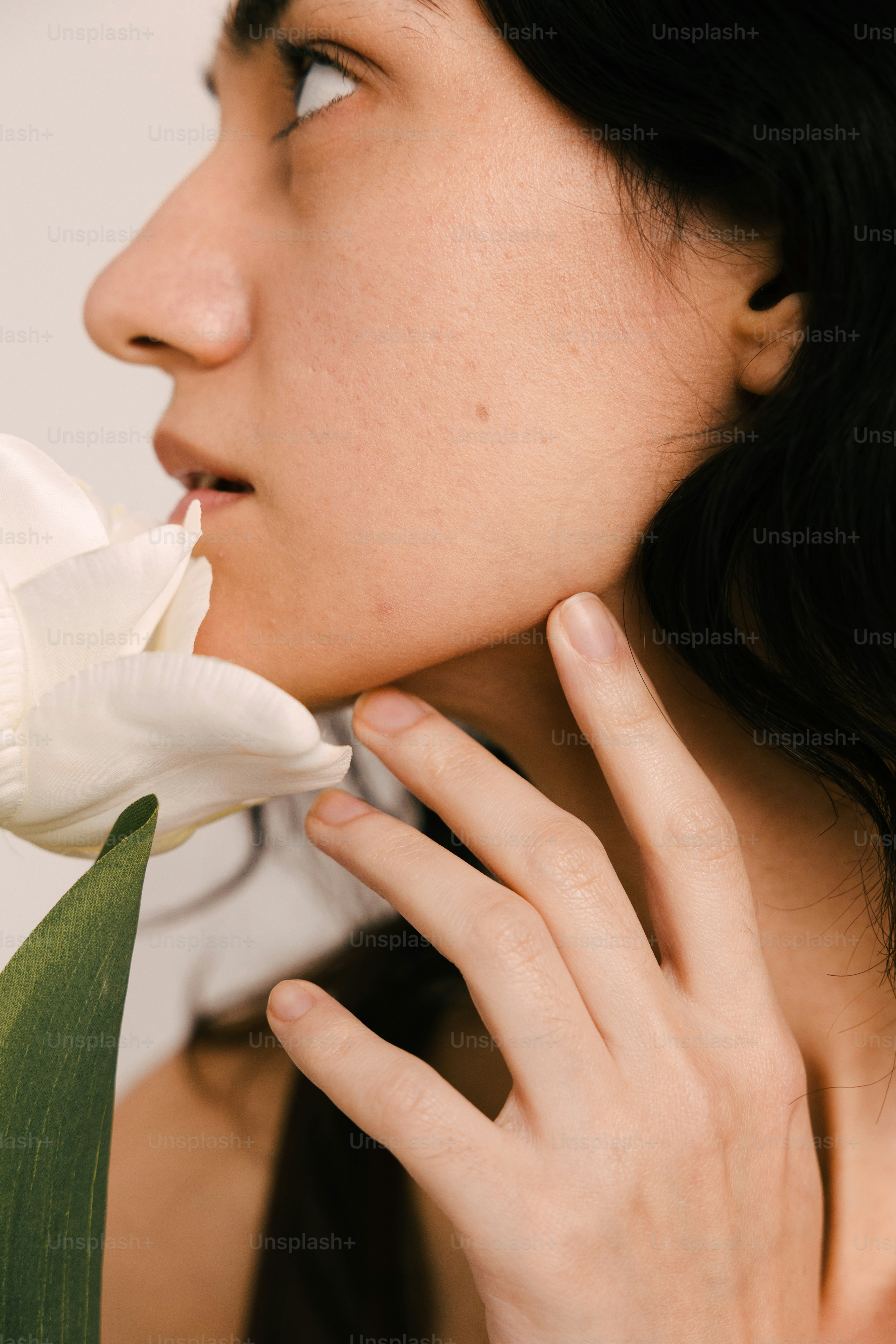 a woman smelling a flower with her hand