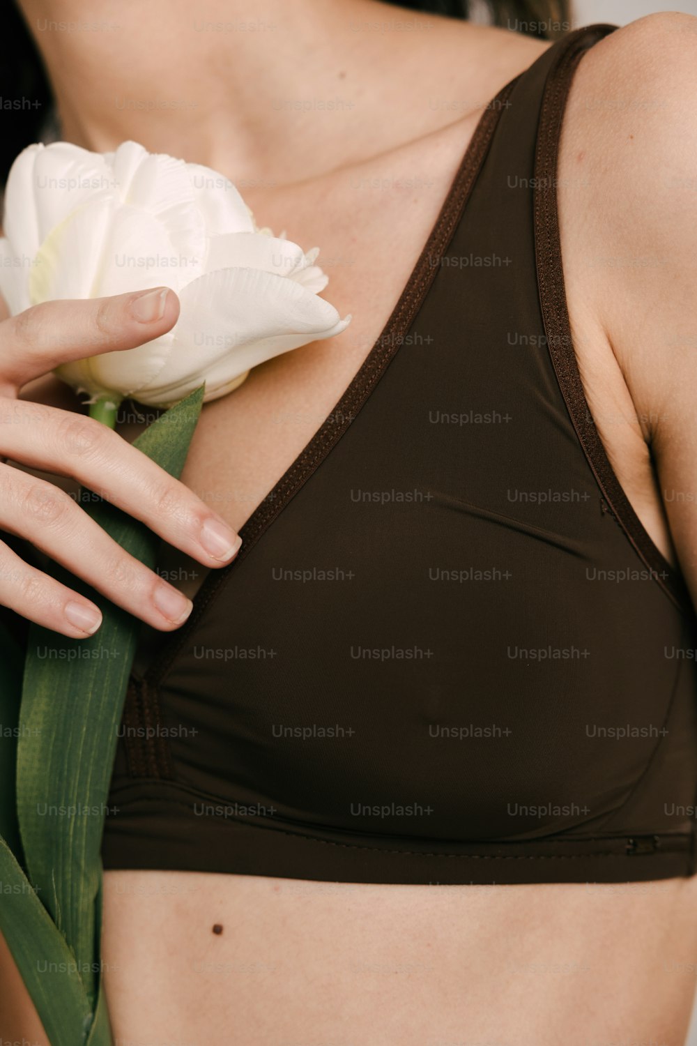 Eine Frau trägt einen BH mit einer Blume in der Hand