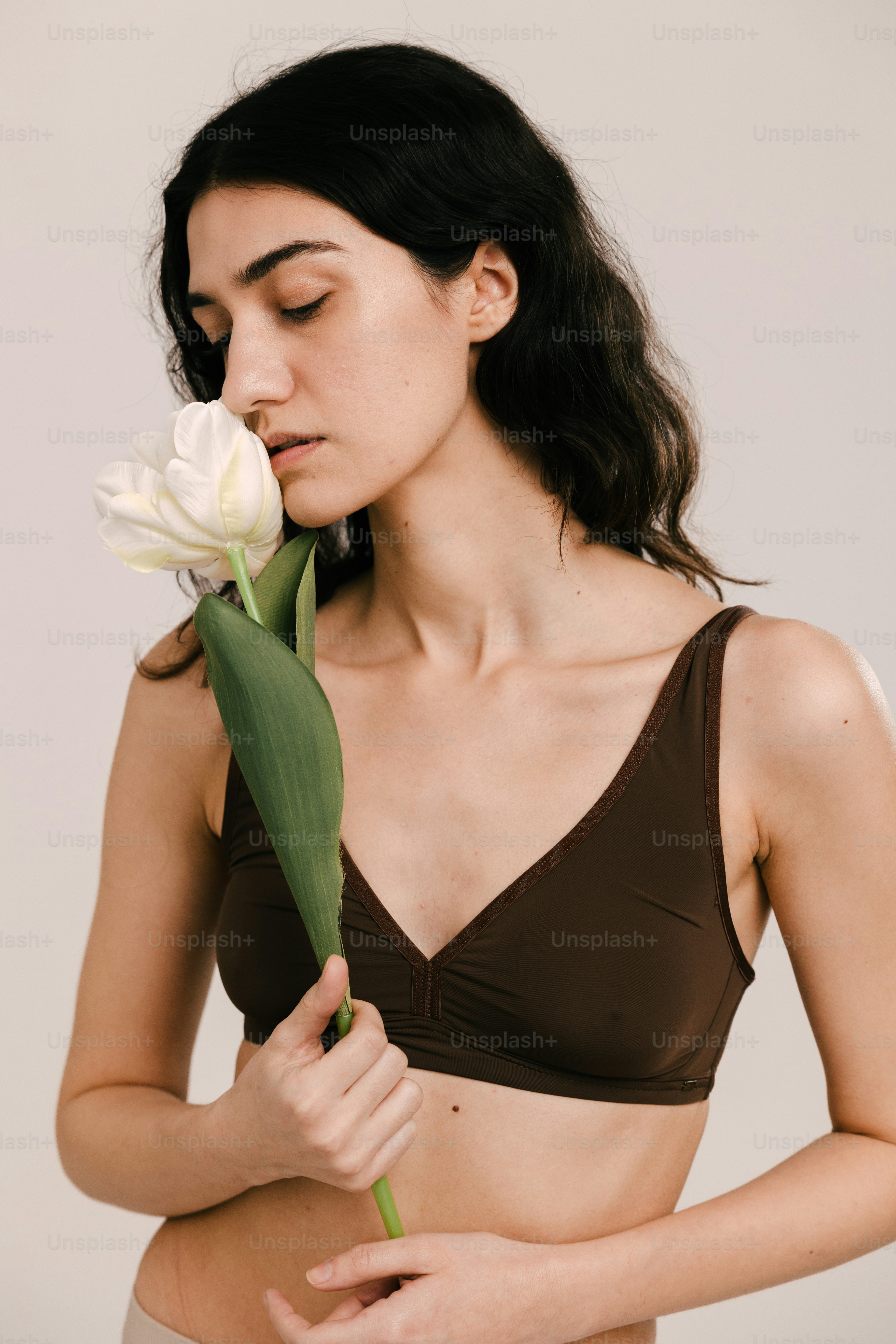 a woman in a bikini holding a flower
