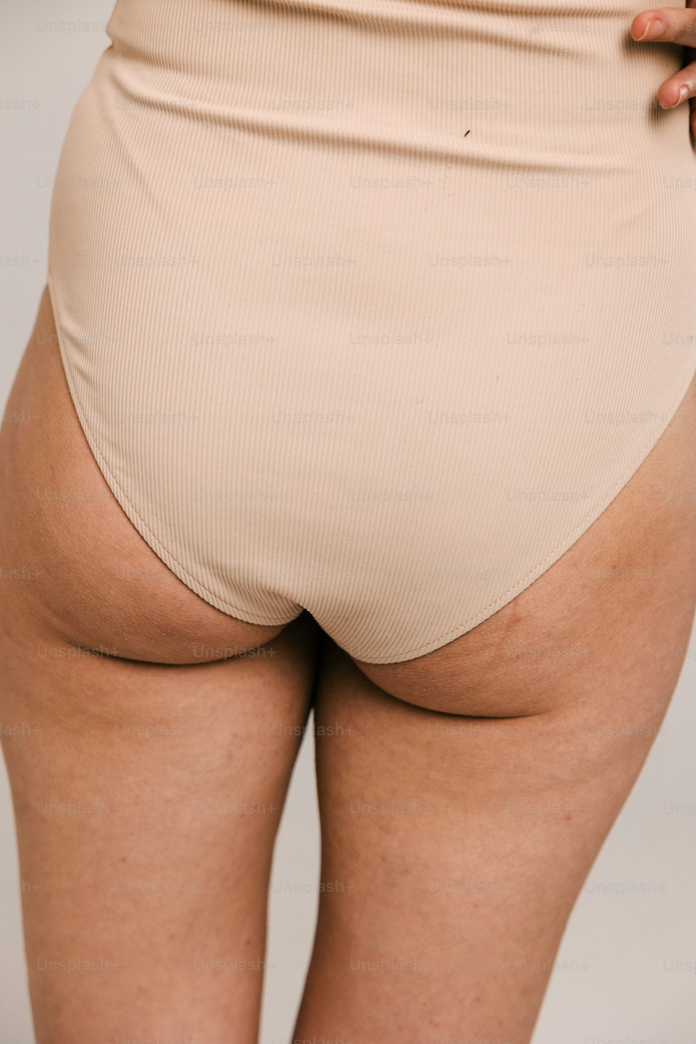 a woman in a tan panties showing her butt