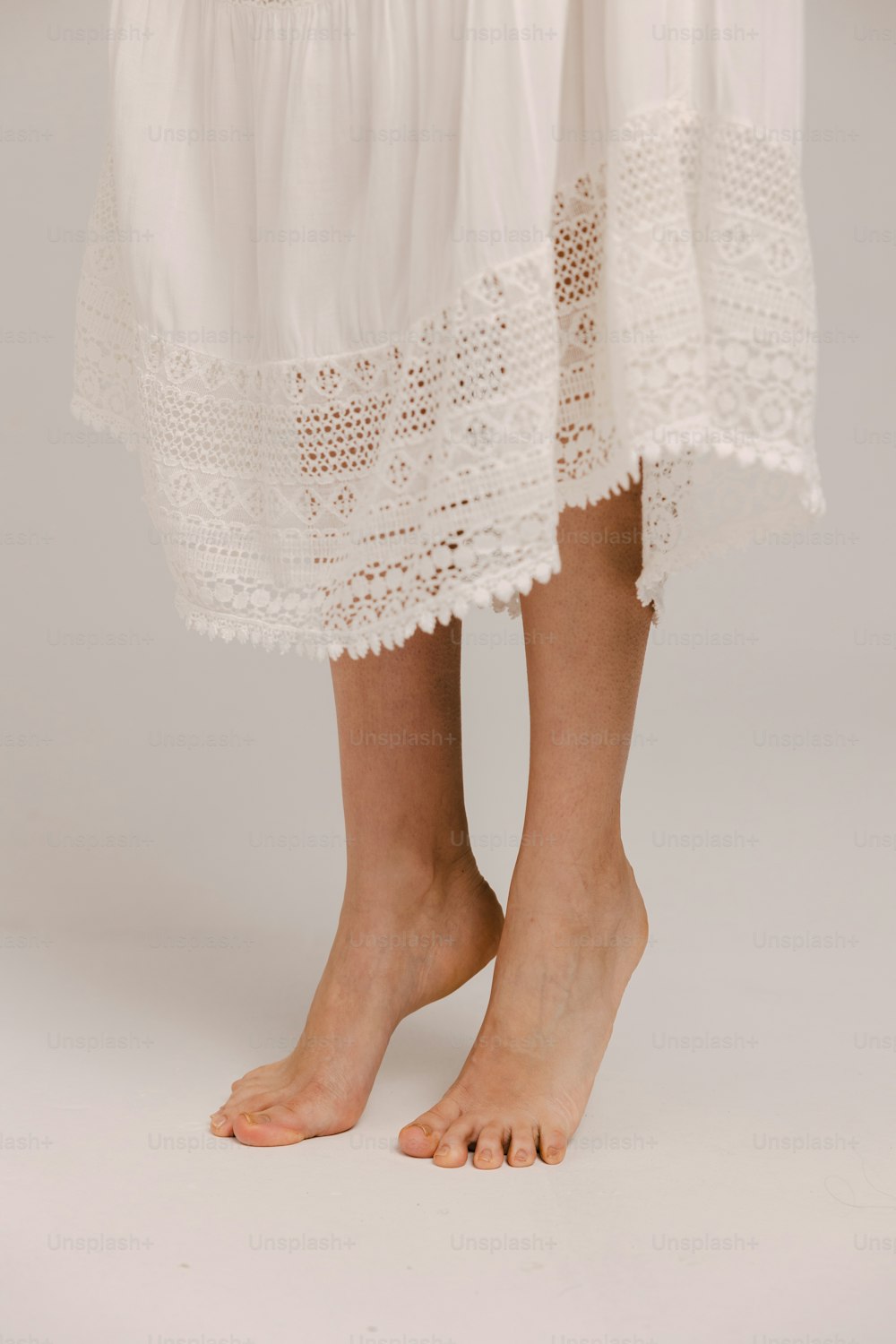 un primer plano de las piernas de una persona con un vestido blanco