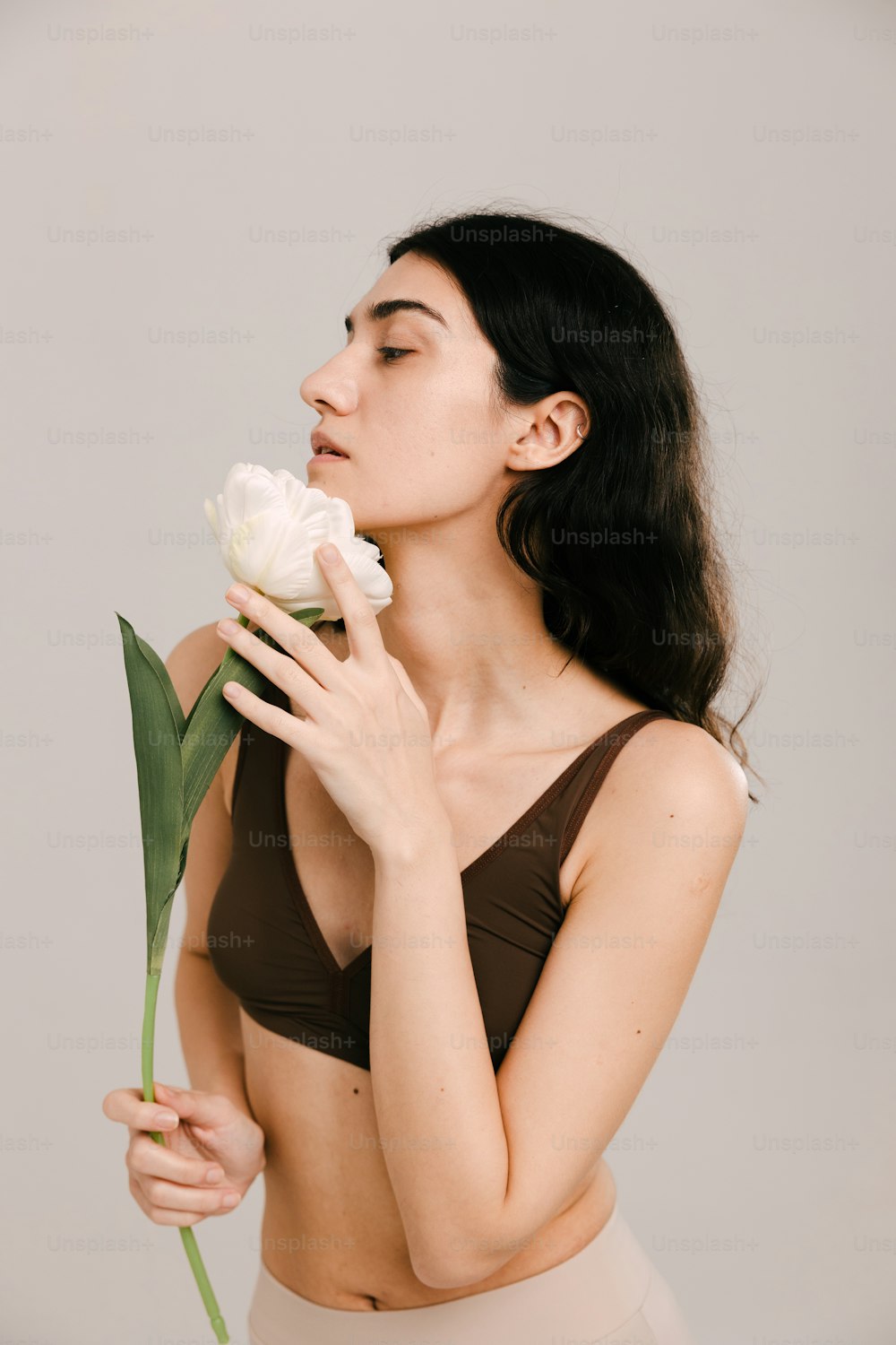 a woman in a bikini holding a flower