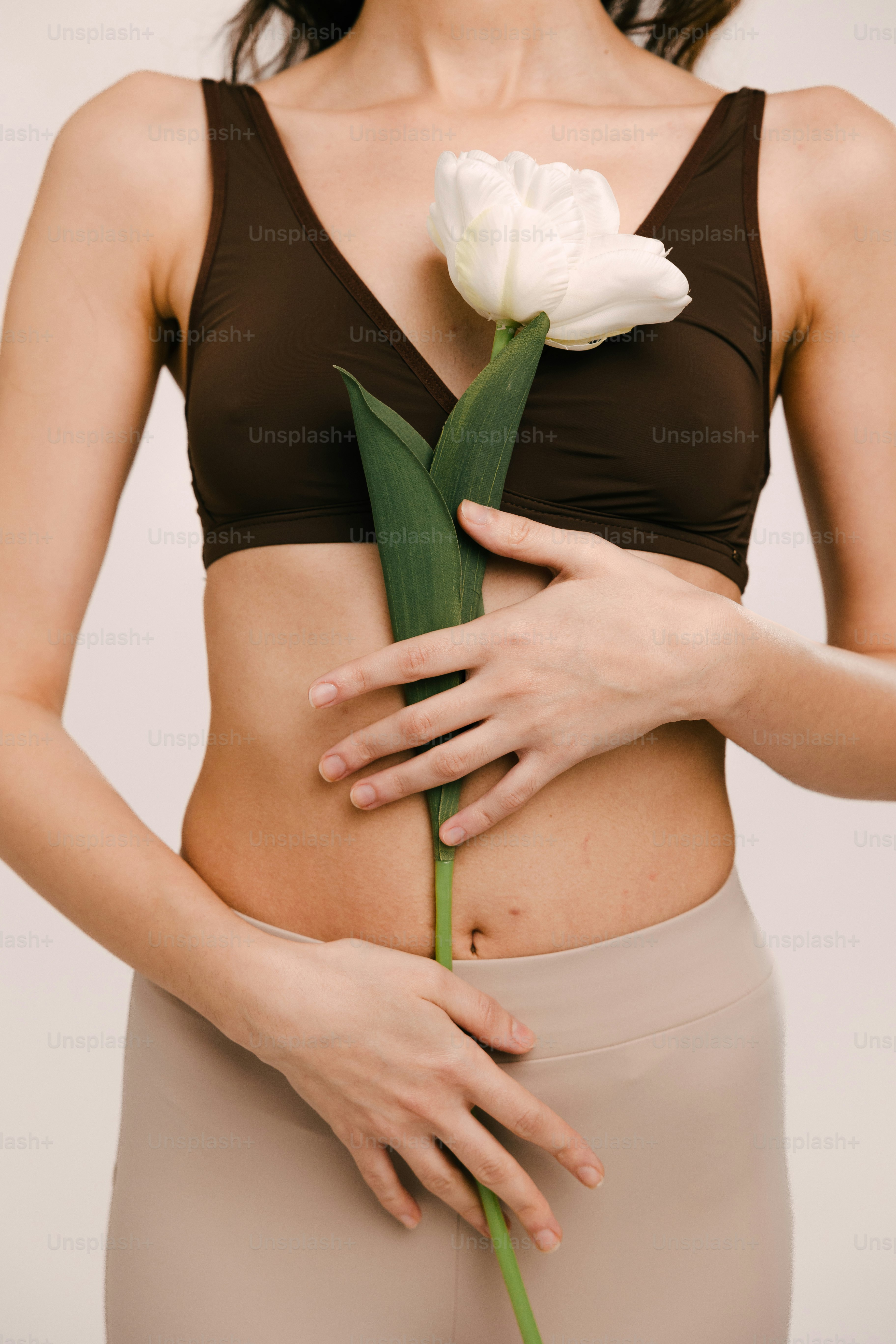 a woman holding a flower in her stomach