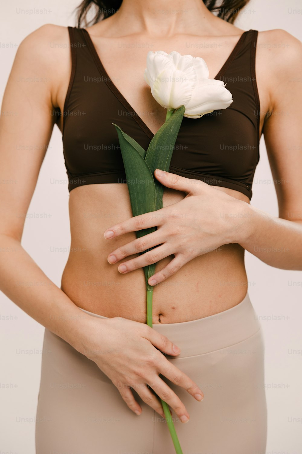 Una mujer sosteniendo una flor en su estómago