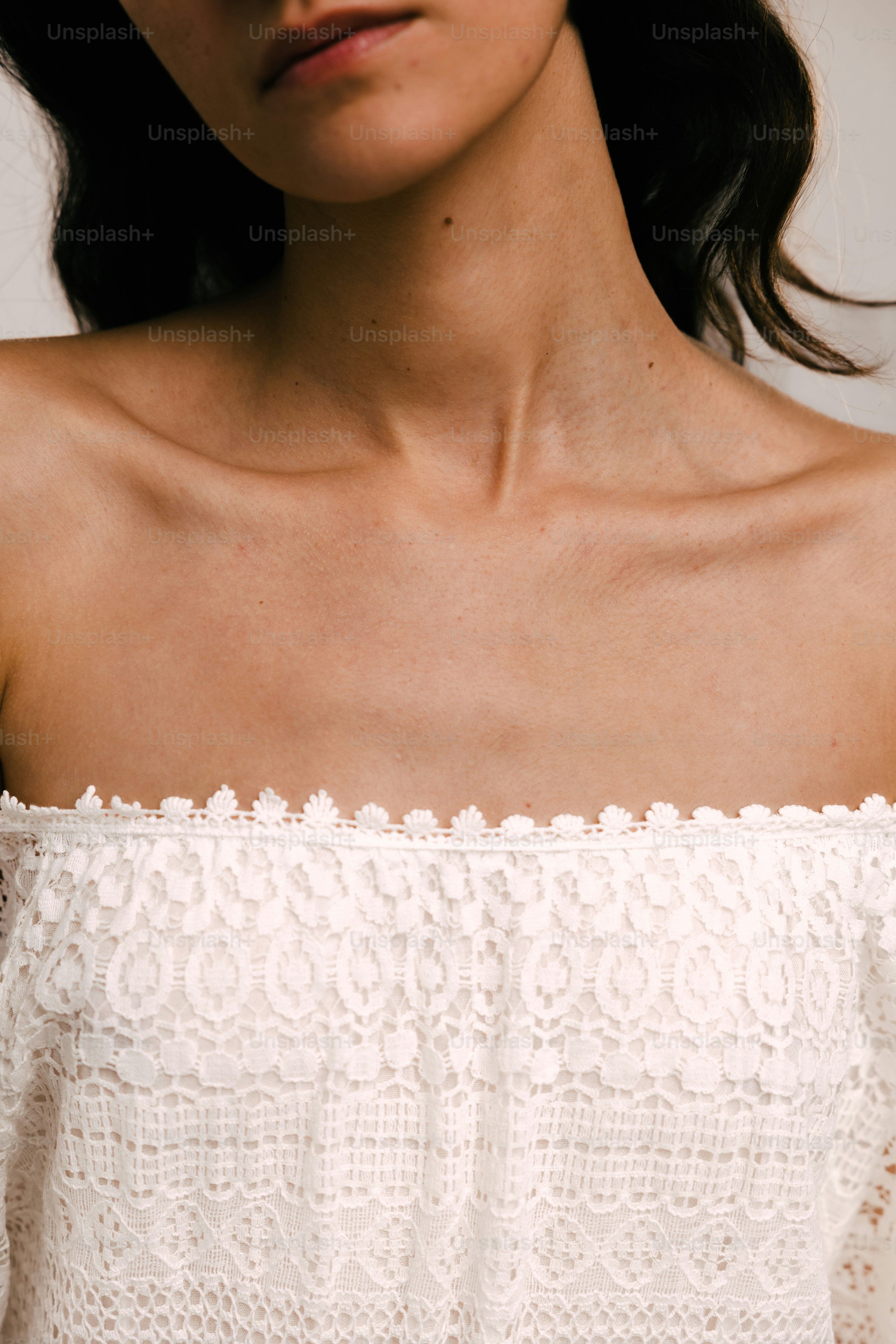 une femme portant un haut blanc et un collier