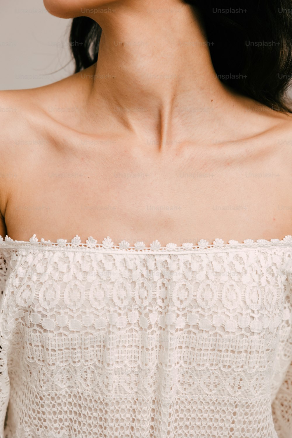 a close up of a woman wearing a white top