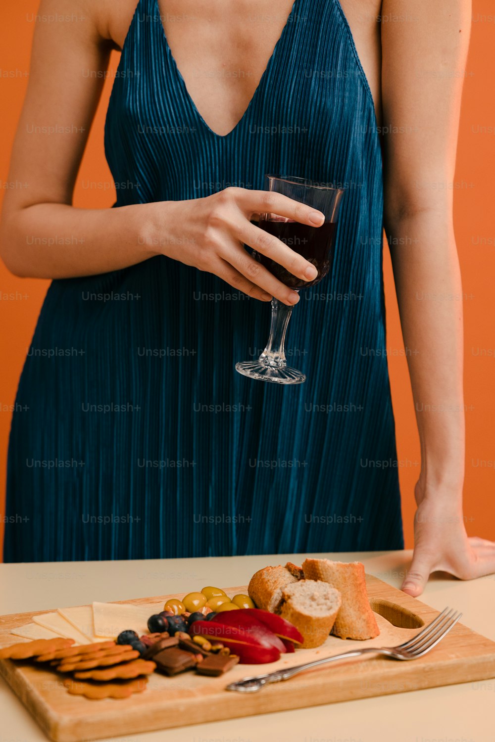 a woman in a blue dress holding a glass of wine
