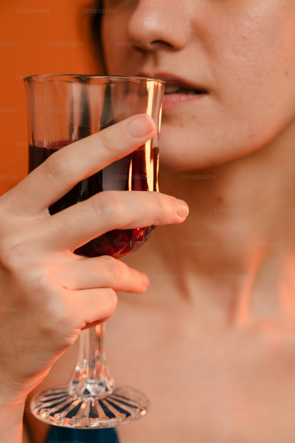 uma mulher segurando um copo de vinho tinto