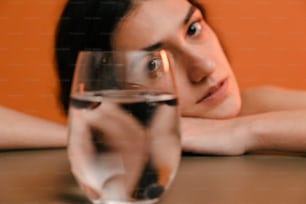 와인 한 잔과 함께 테이블에 앉아 있는 여자