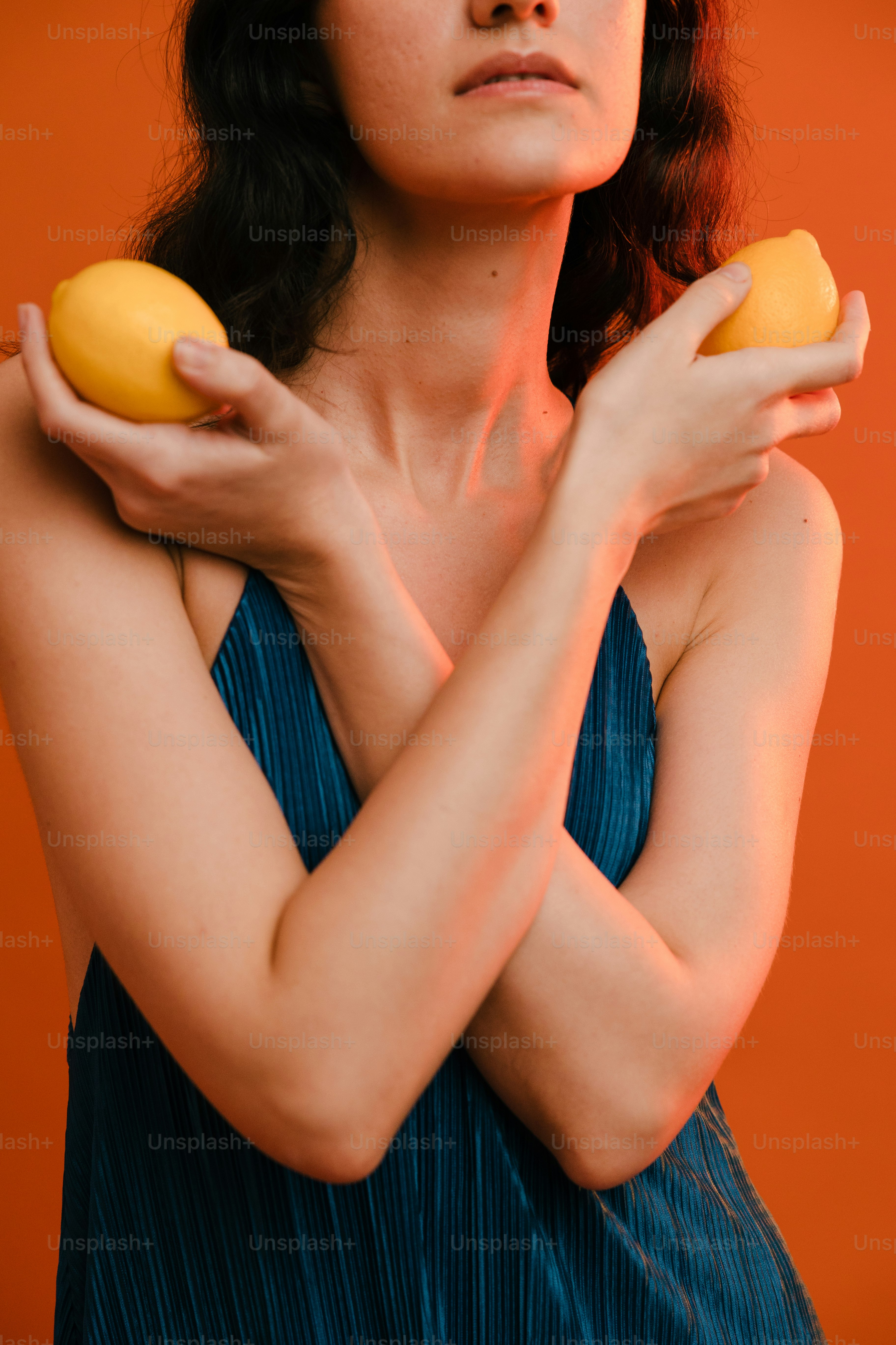 a woman in a blue dress holding two donuts