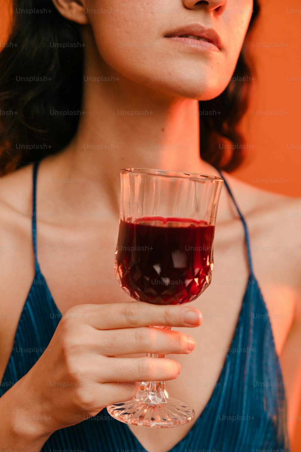 a woman holding a glass of red wine