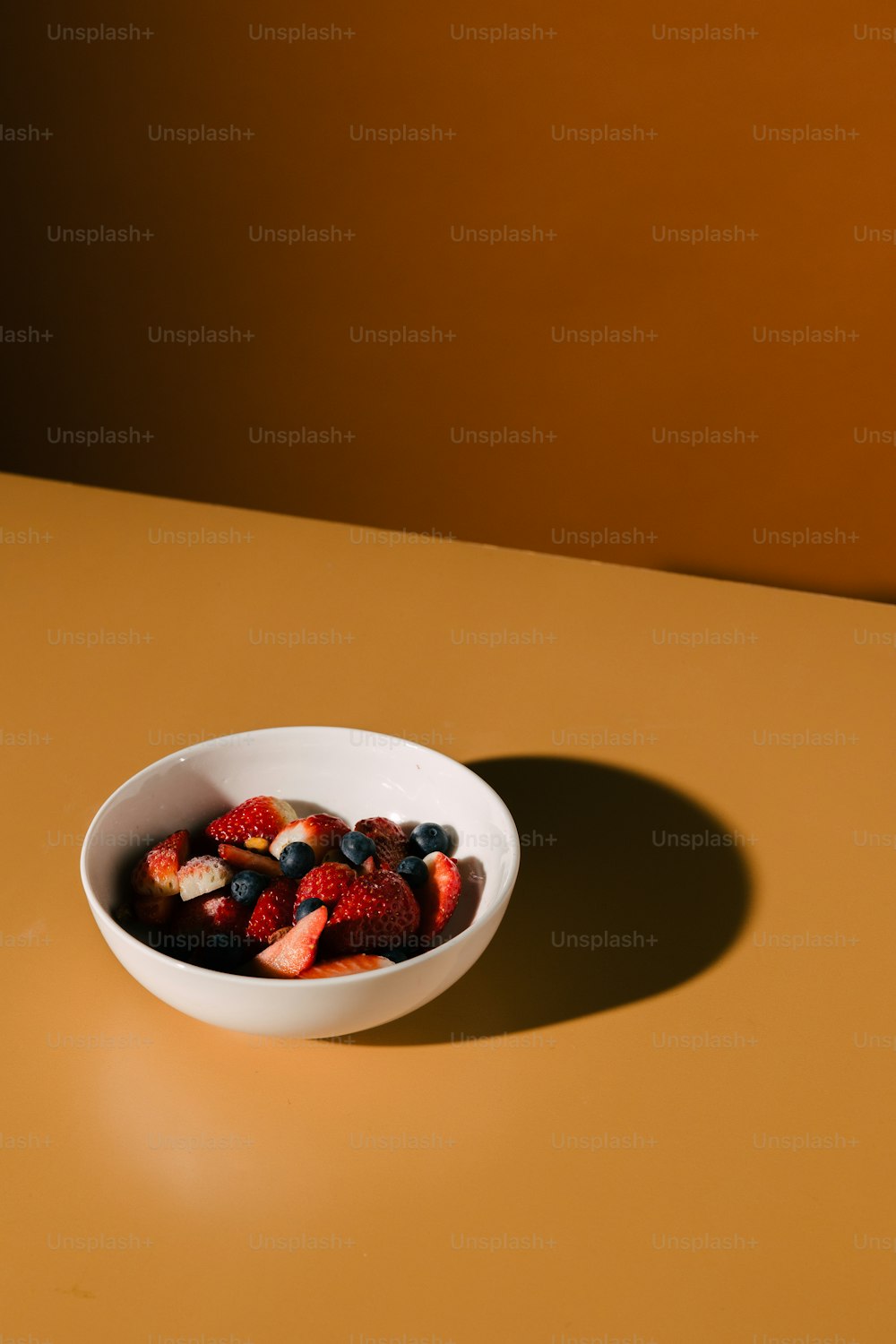 a bowl of strawberries and blueberries on a table