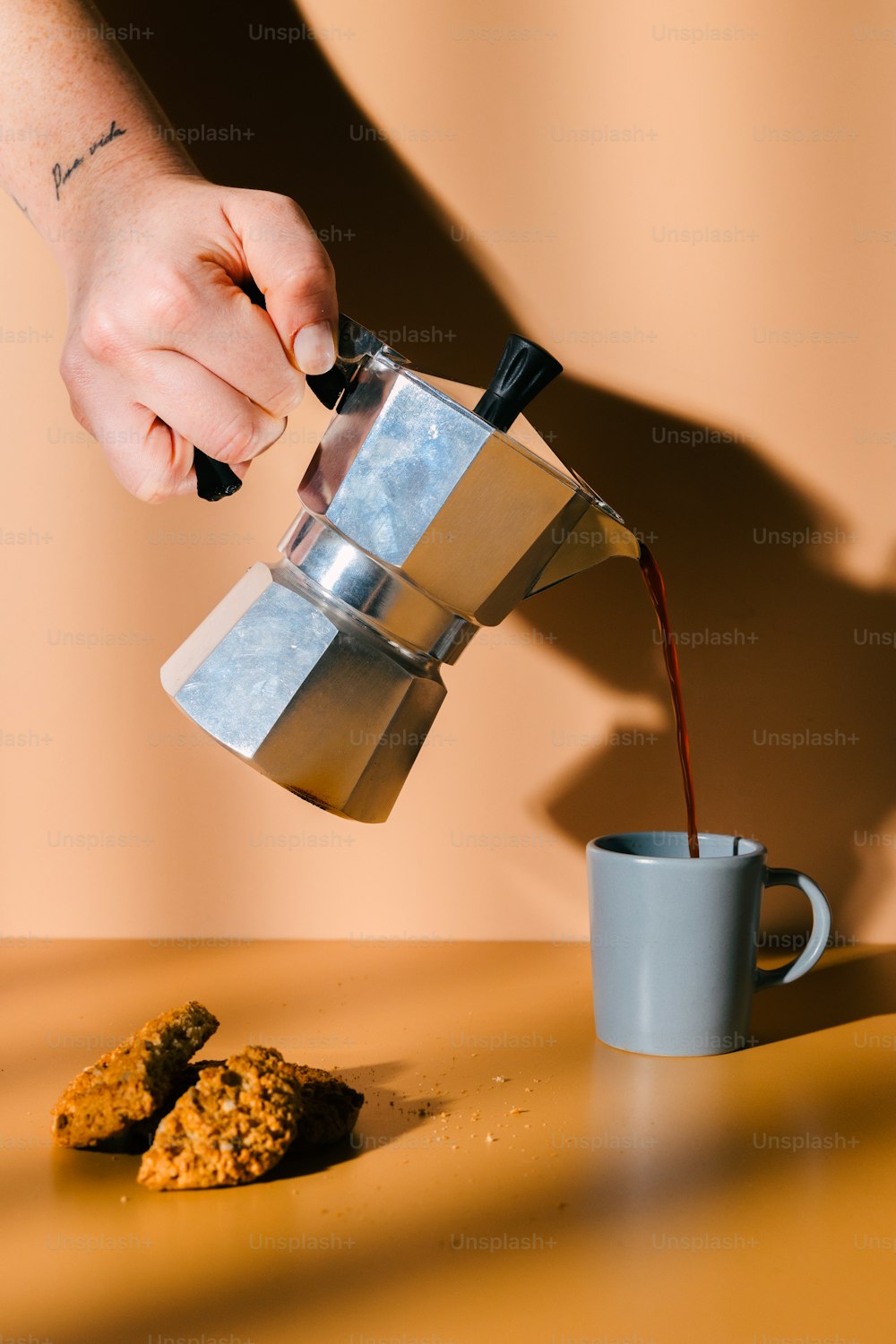 Eine Person, die Kaffee in eine Tasse gießt