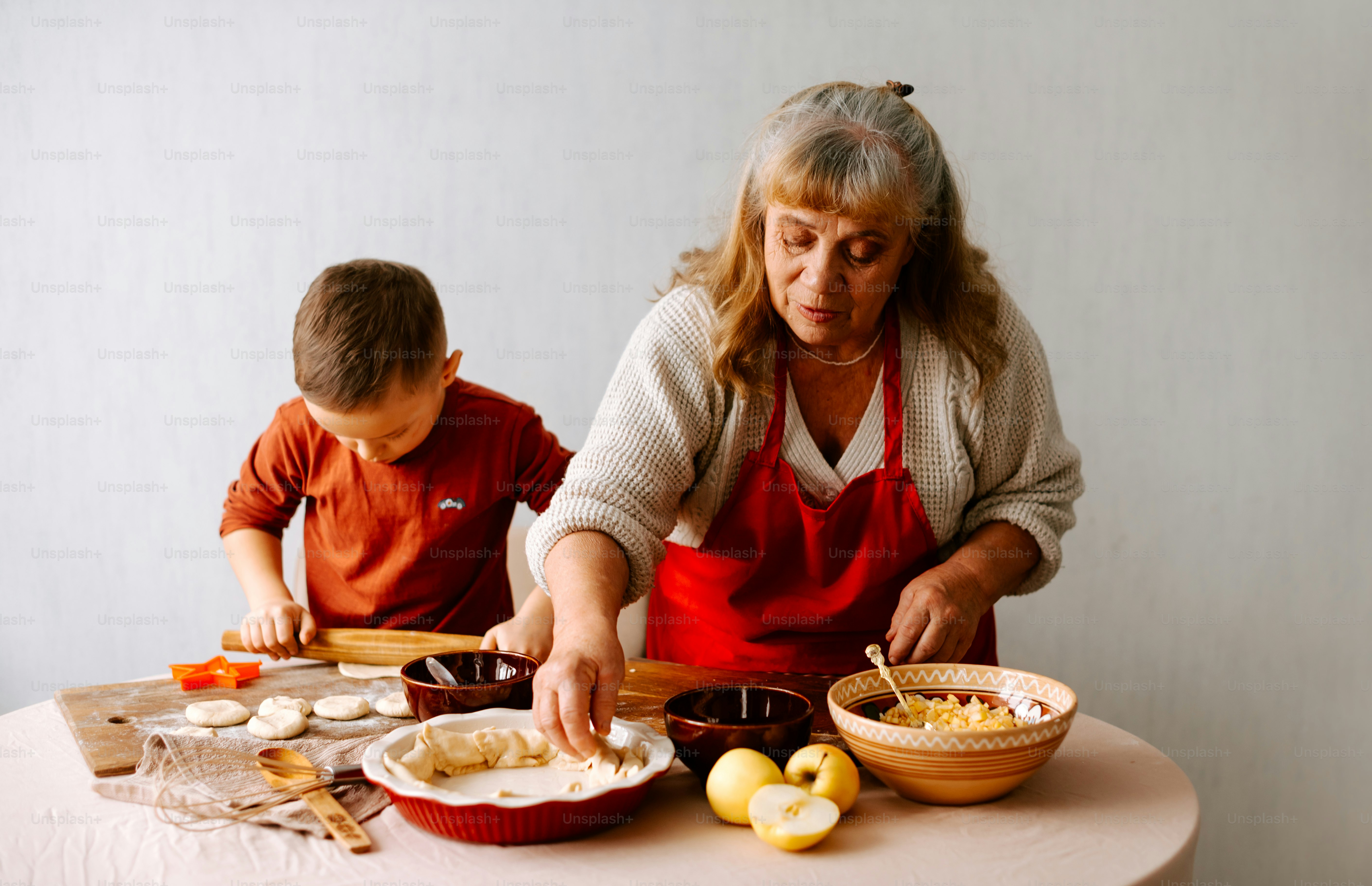 eine ältere Frau und ein kleiner Junge bereiten Essen zu