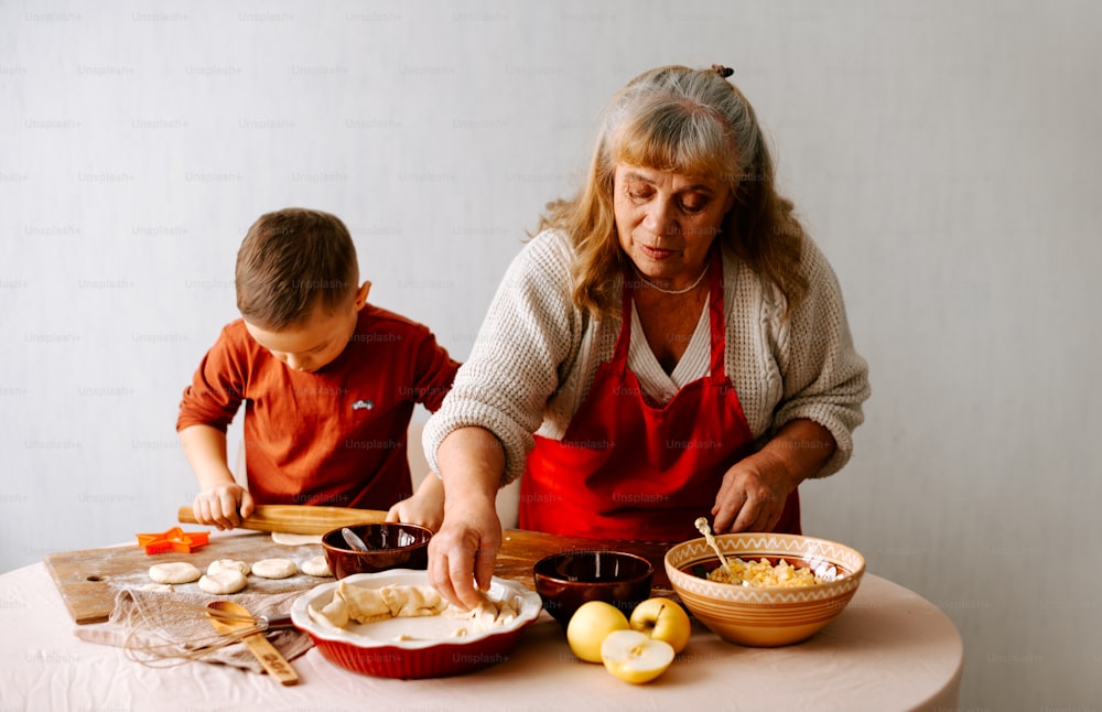 una mujer mayor y un niño preparando comida