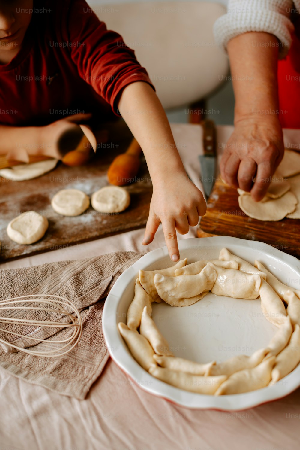 a woman and a child are making pizza dough