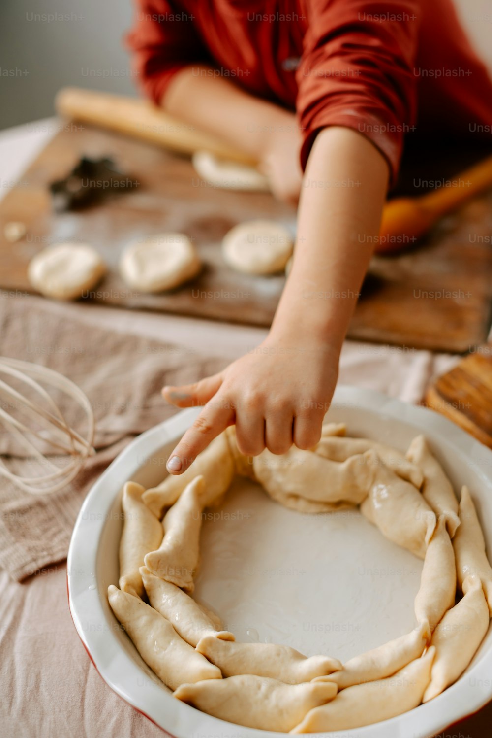 a person putting dough into a bowl on a table