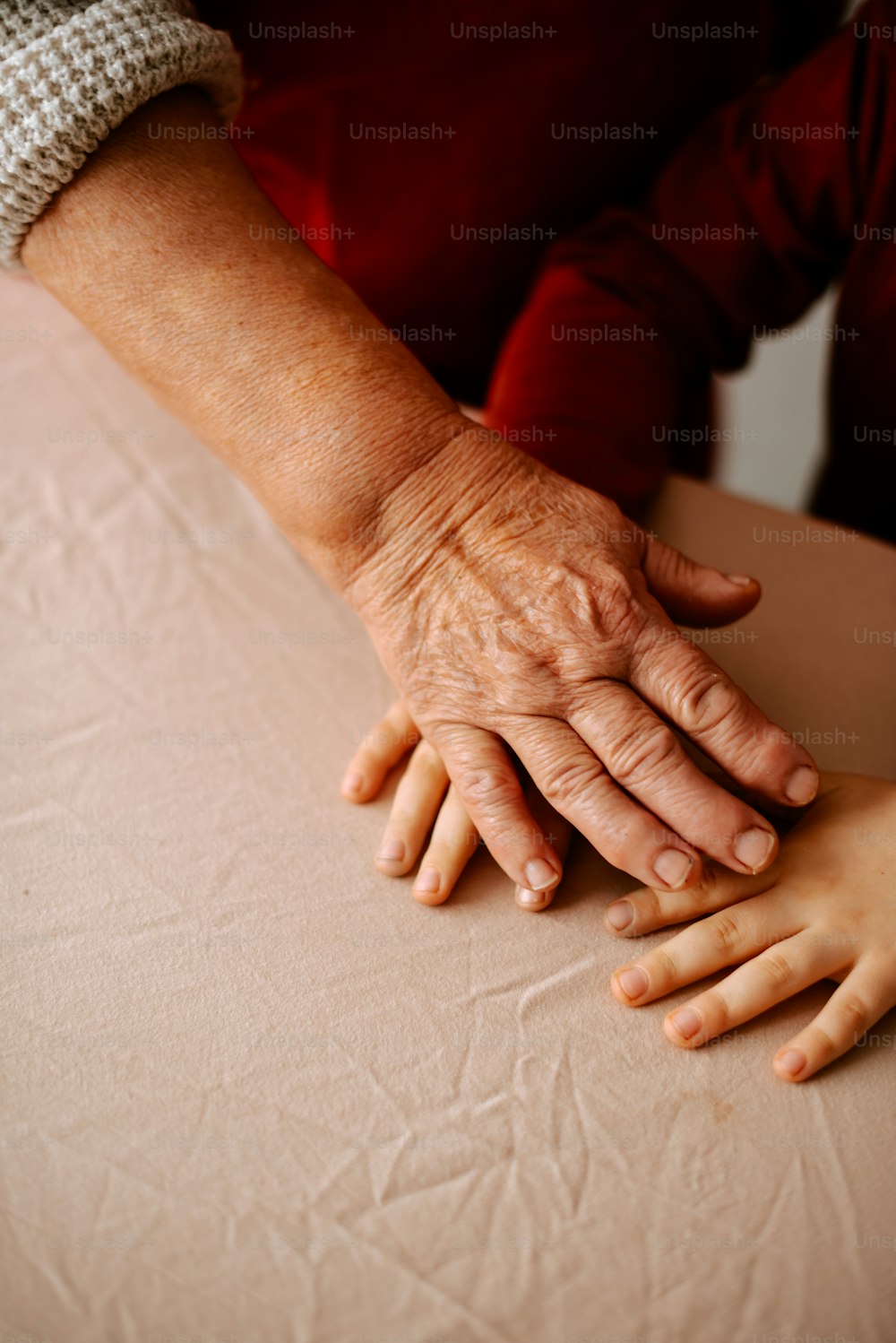 a woman holding a child's hand on top of a table