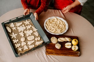 a person sitting at a table with a tray of cookies