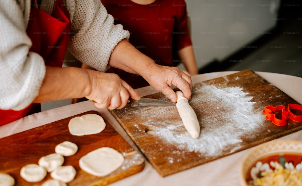 a woman and a child are preparing food on a cutting board