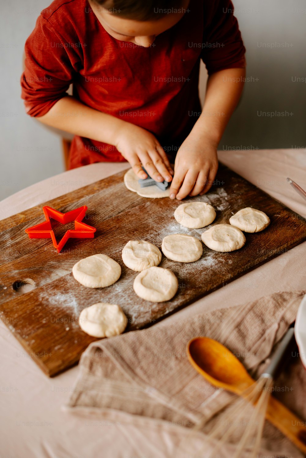 어린 소년이 테이블에서 쿠키를 만들고 있다