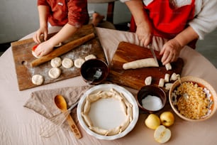 a couple of people are preparing food on a table