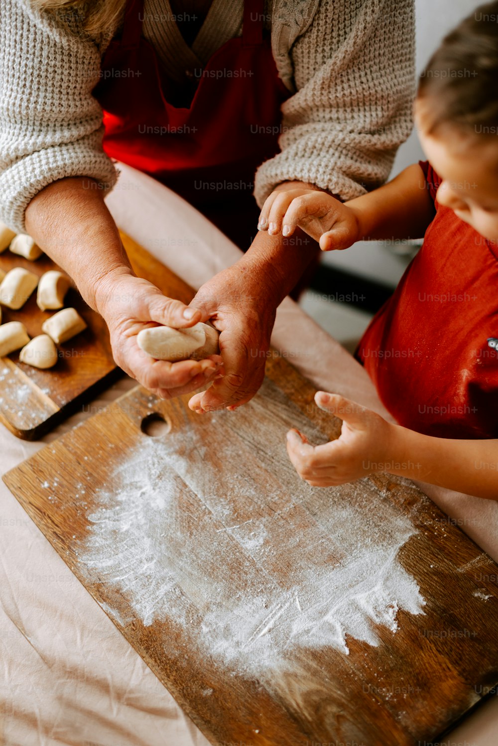a woman and a child are making dough