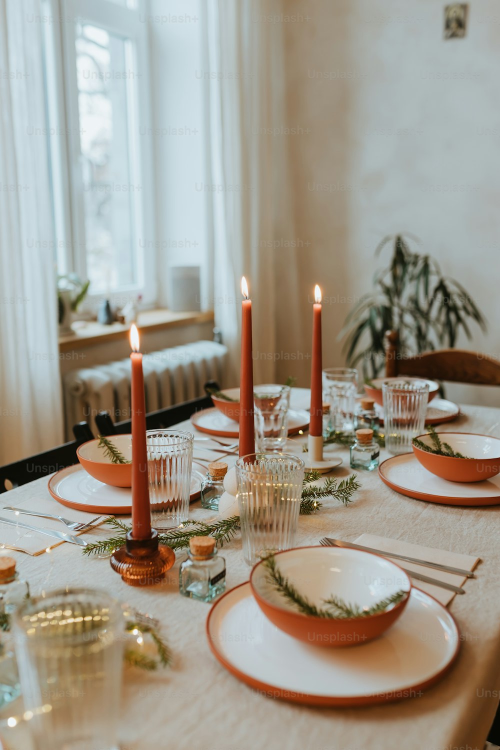 a table set with plates and candles for a holiday dinner