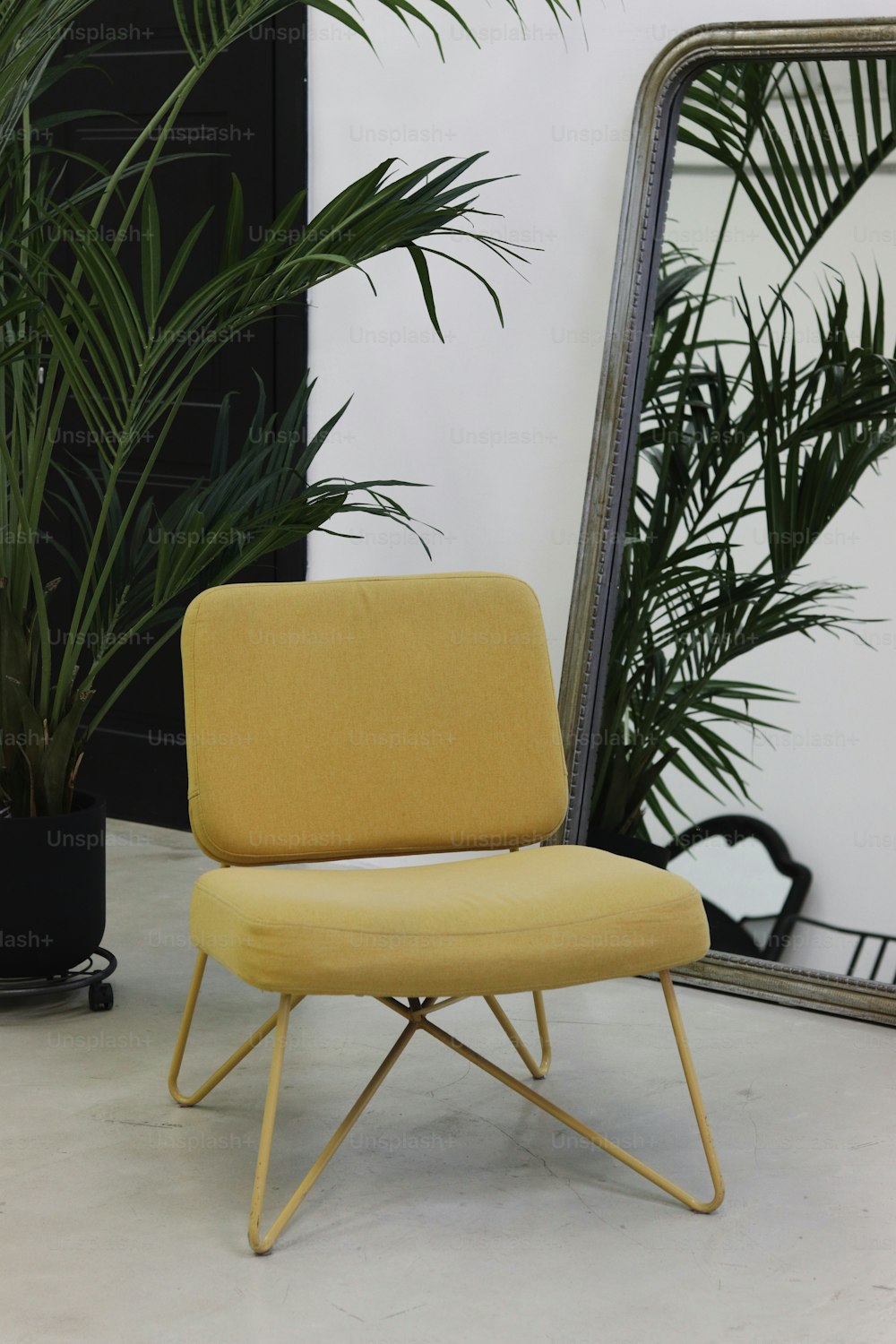 a yellow chair sitting in front of a mirror