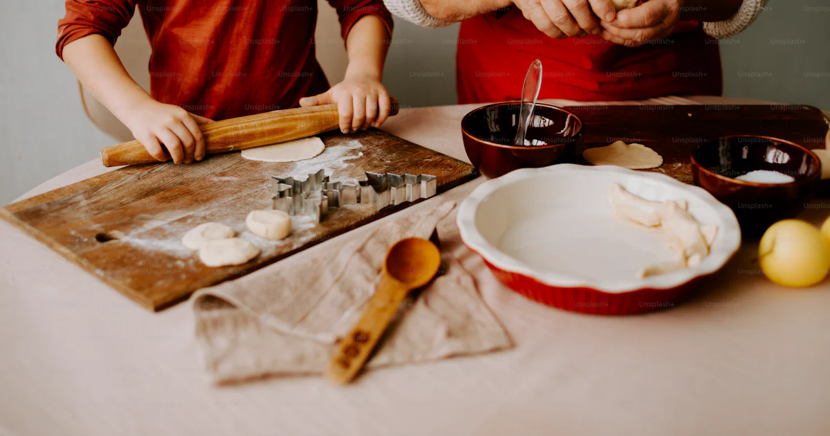 Human Making Food A man and a boy are making food on a table photo – Cooking Image on ...