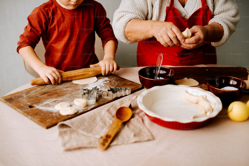 Un hombre y un niño están haciendo comida en una mesa