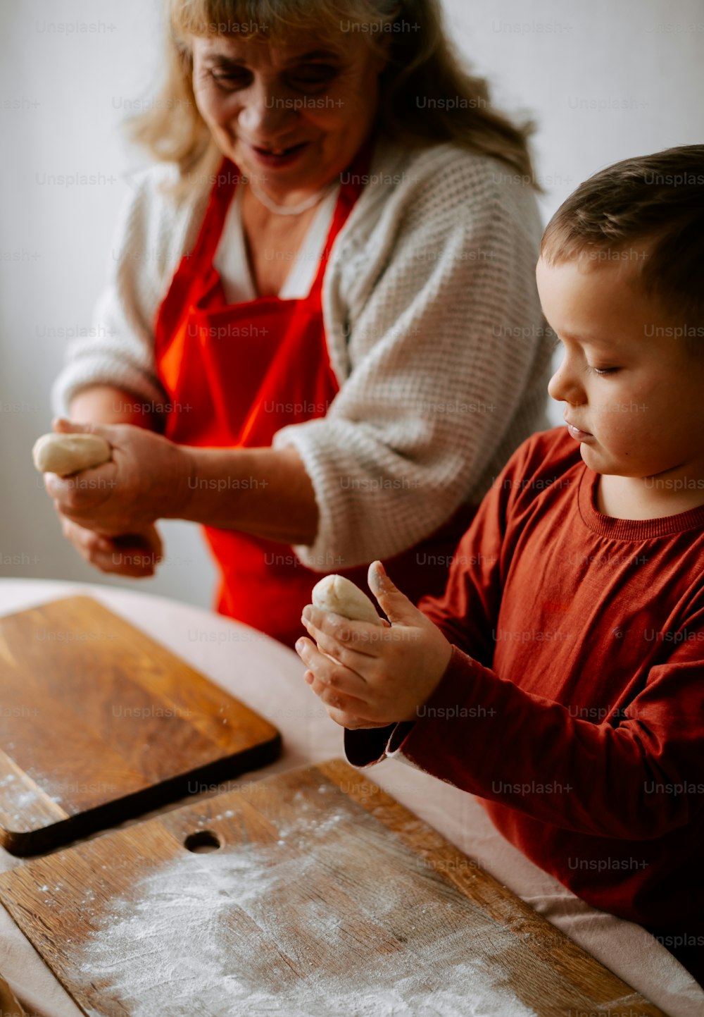 a woman and a child are making doughnuts