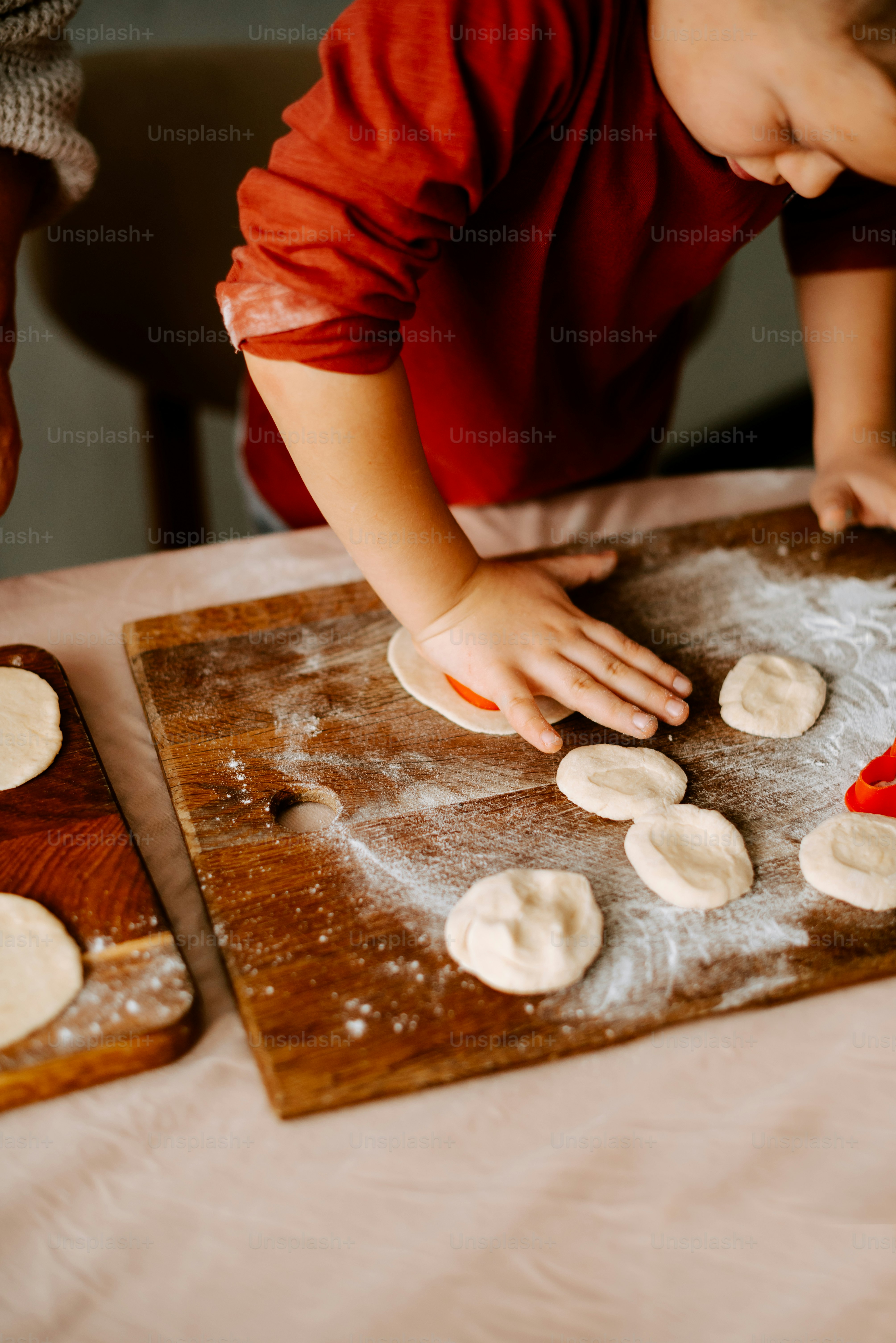 a little boy that is standing in front of a table