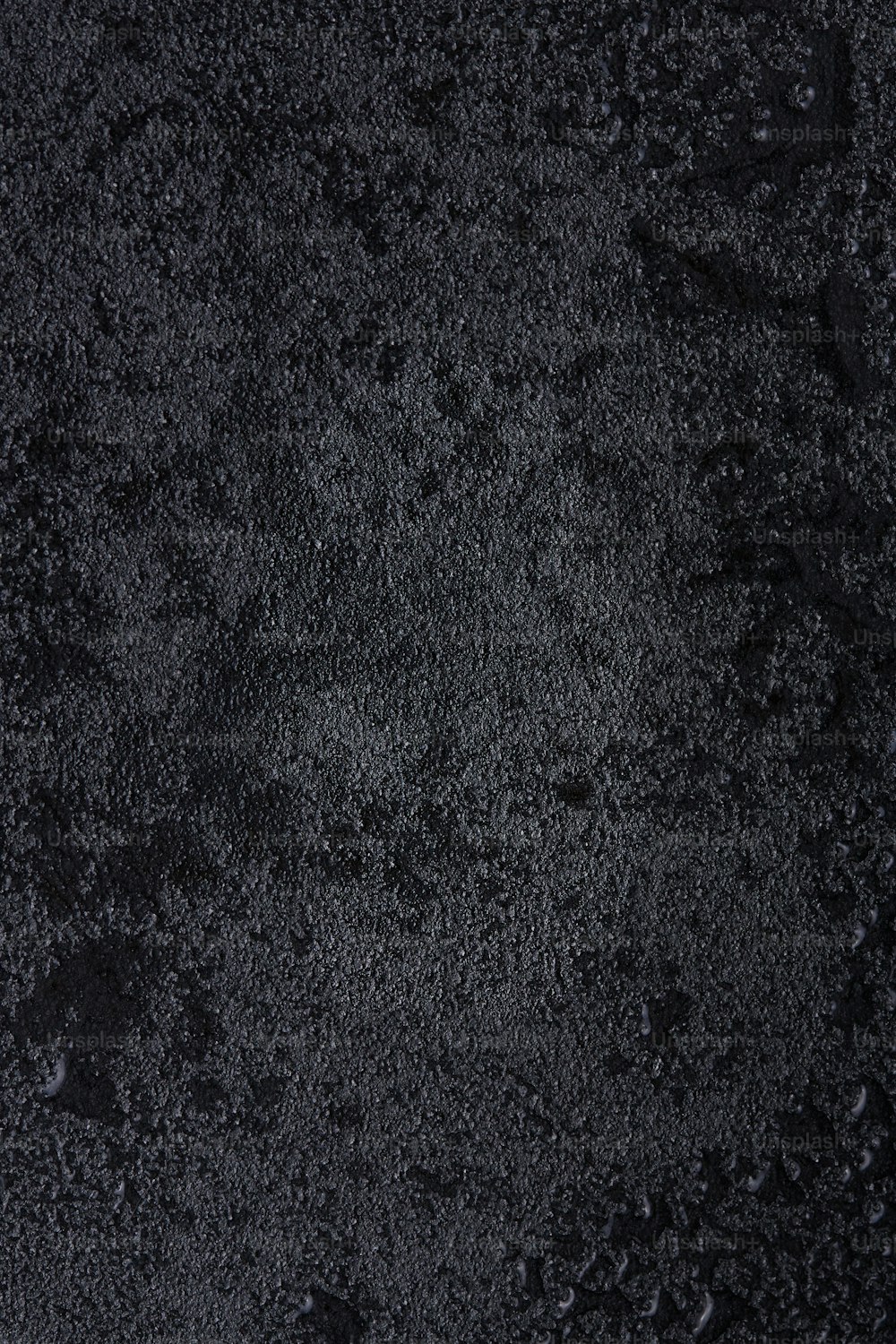 un primer plano de una superficie negra con gotas de agua