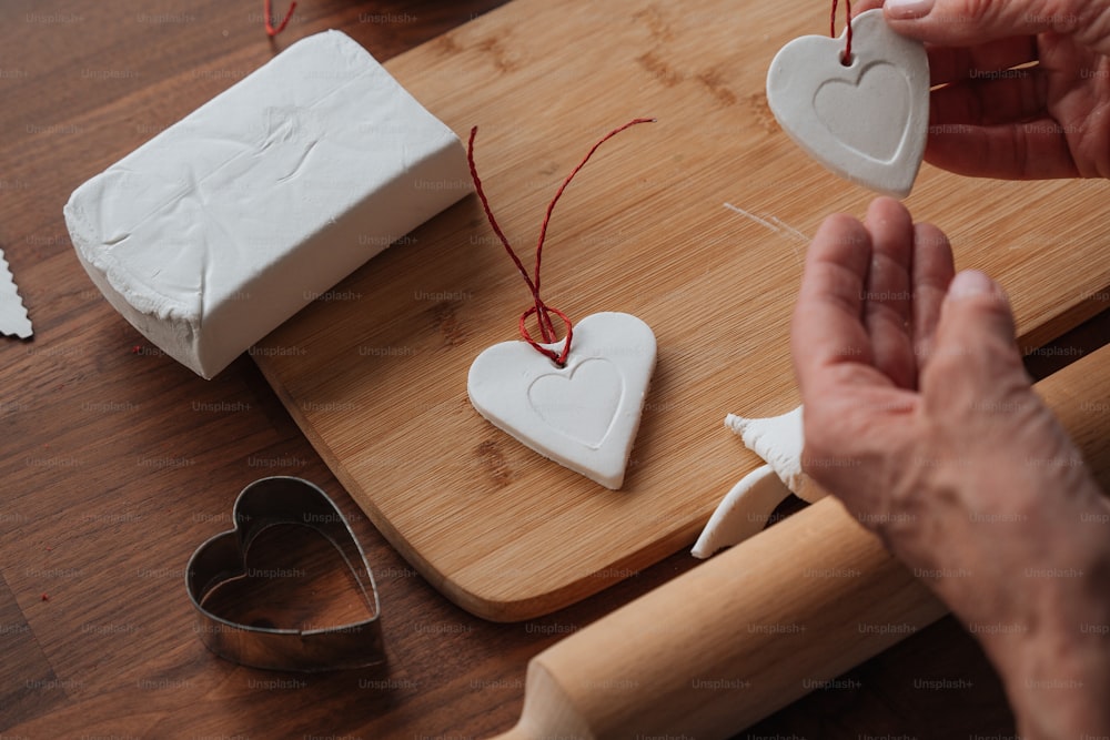 a person is making heart shaped soaps on a cutting board