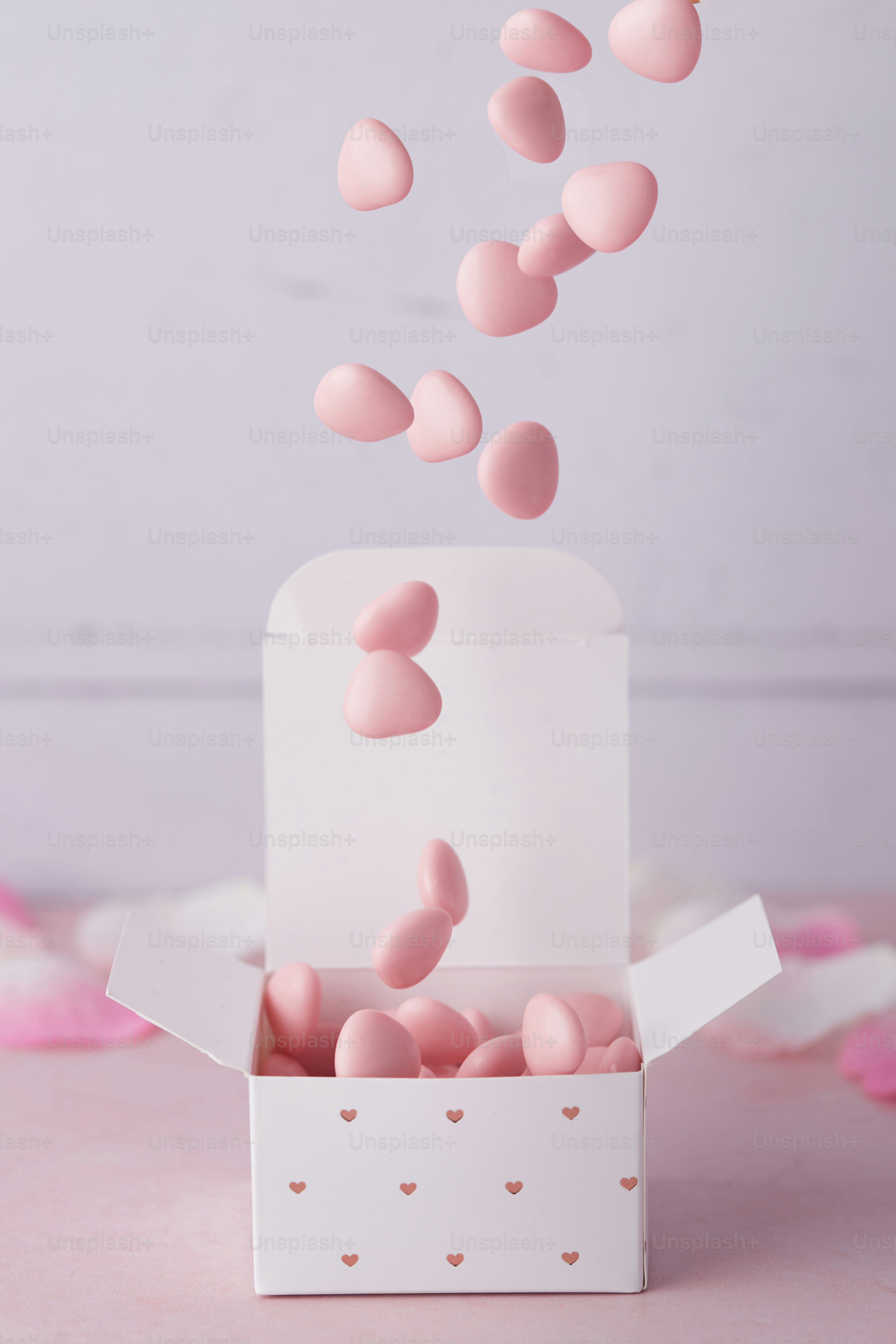 Un pastel rosa con corazones saliendo de él