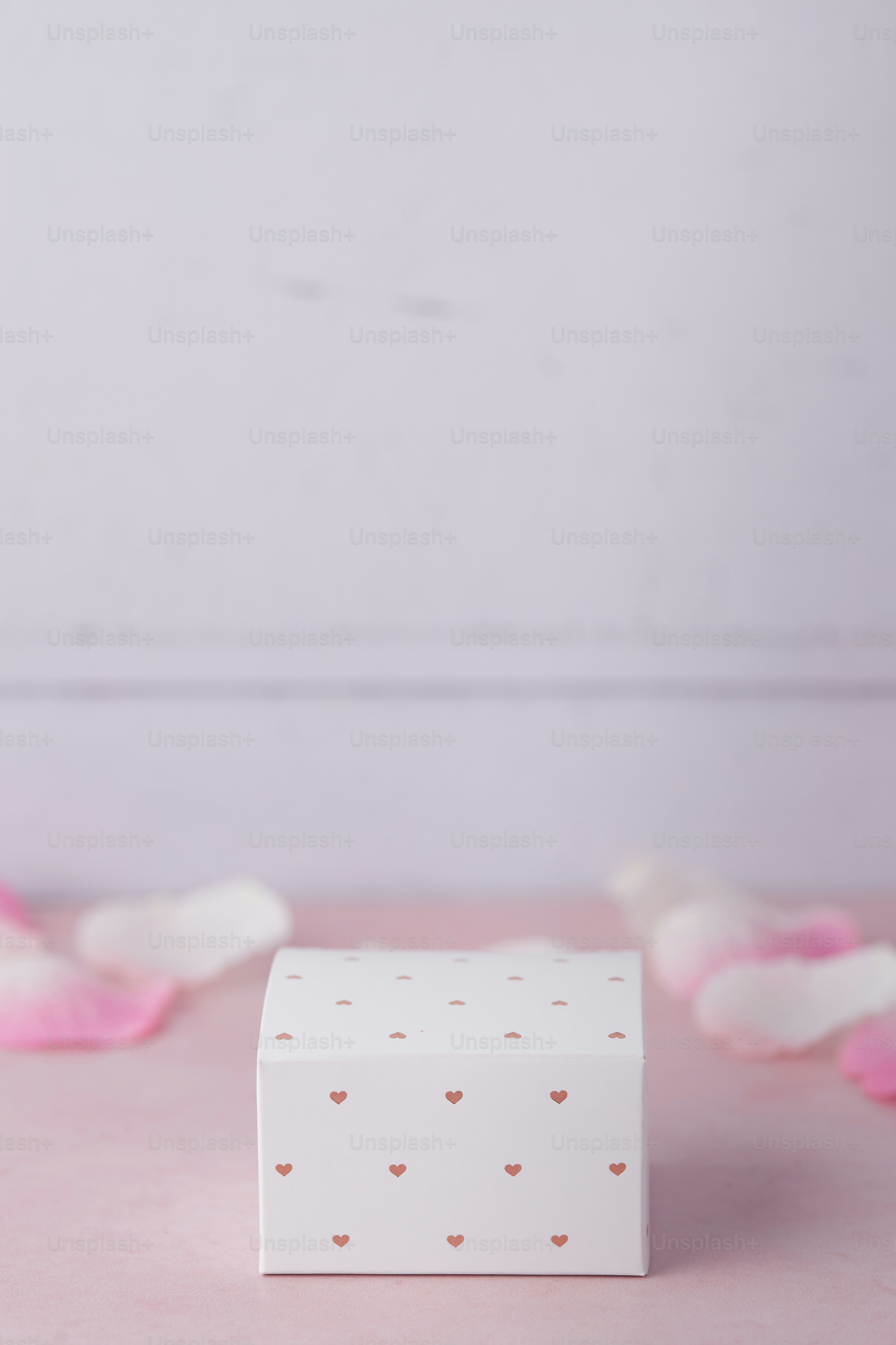 Una caja blanca sentada encima de una mesa rosa