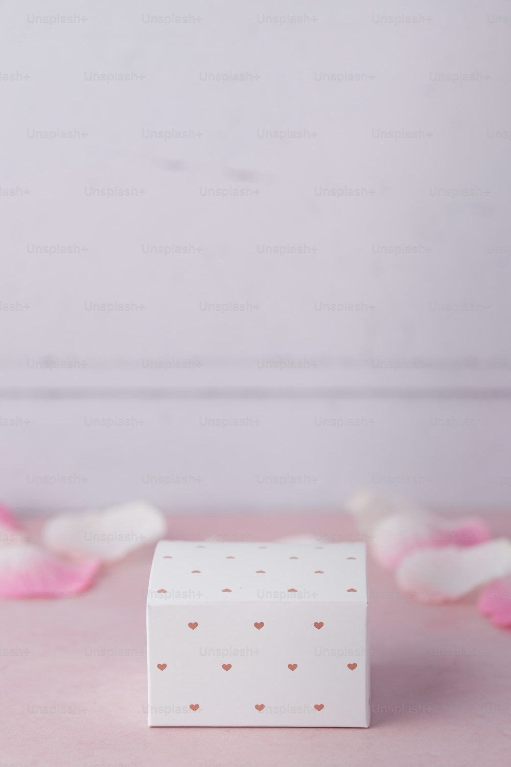 a white box sitting on top of a pink table