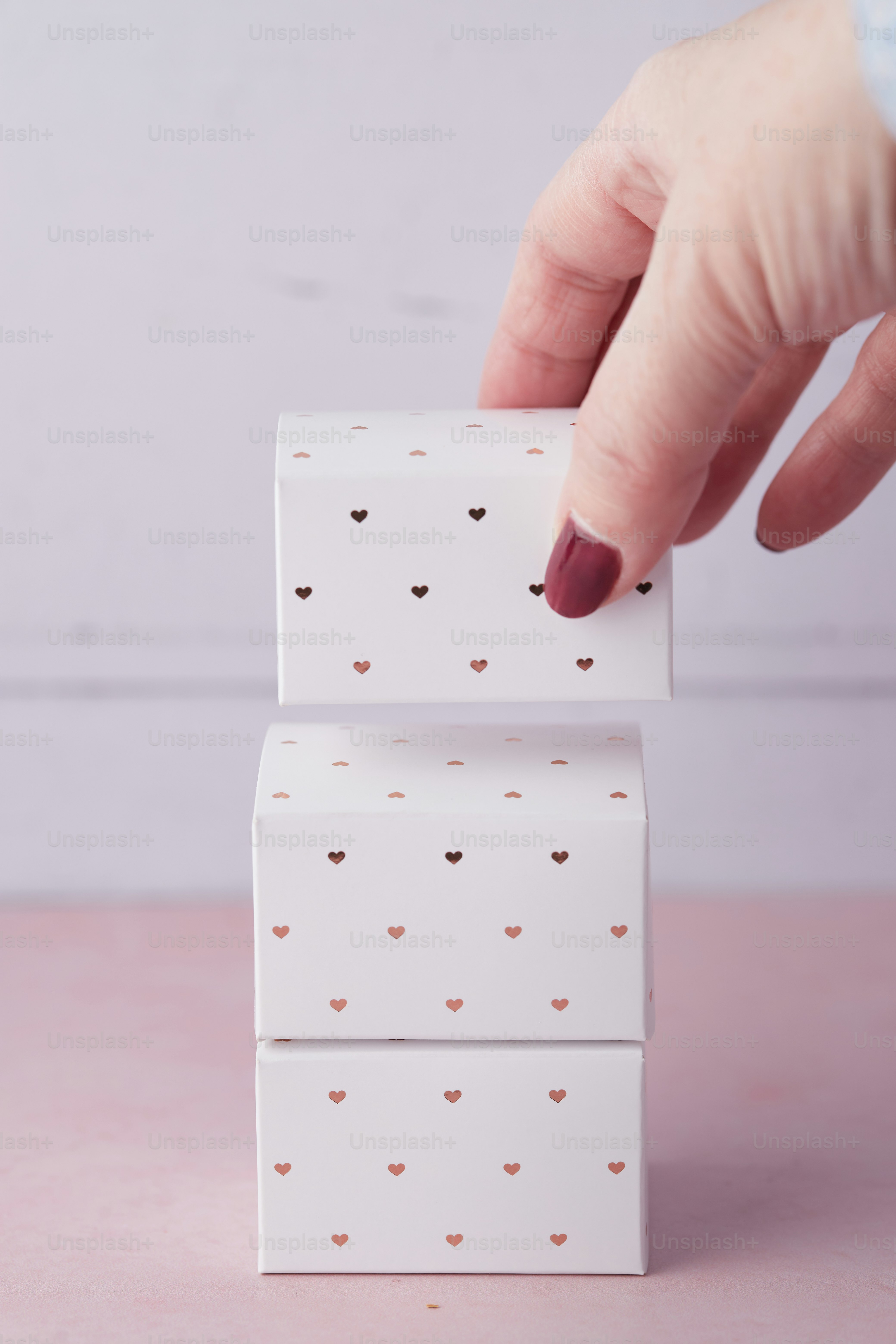 Die Hand einer Frau greift nach einem Stück Papier mit Herzen darauf