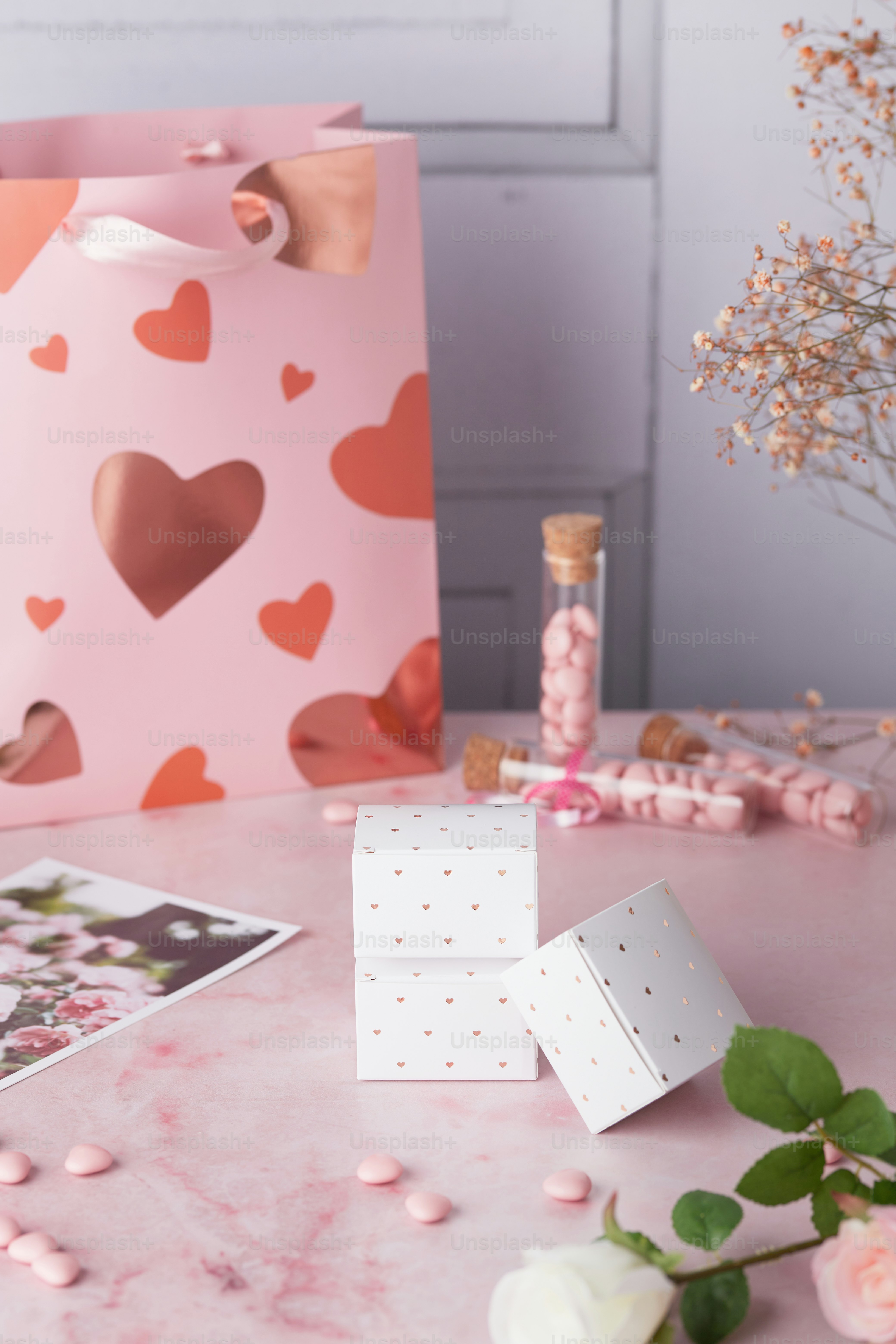 a pink table topped with pink flowers and a pink bag
