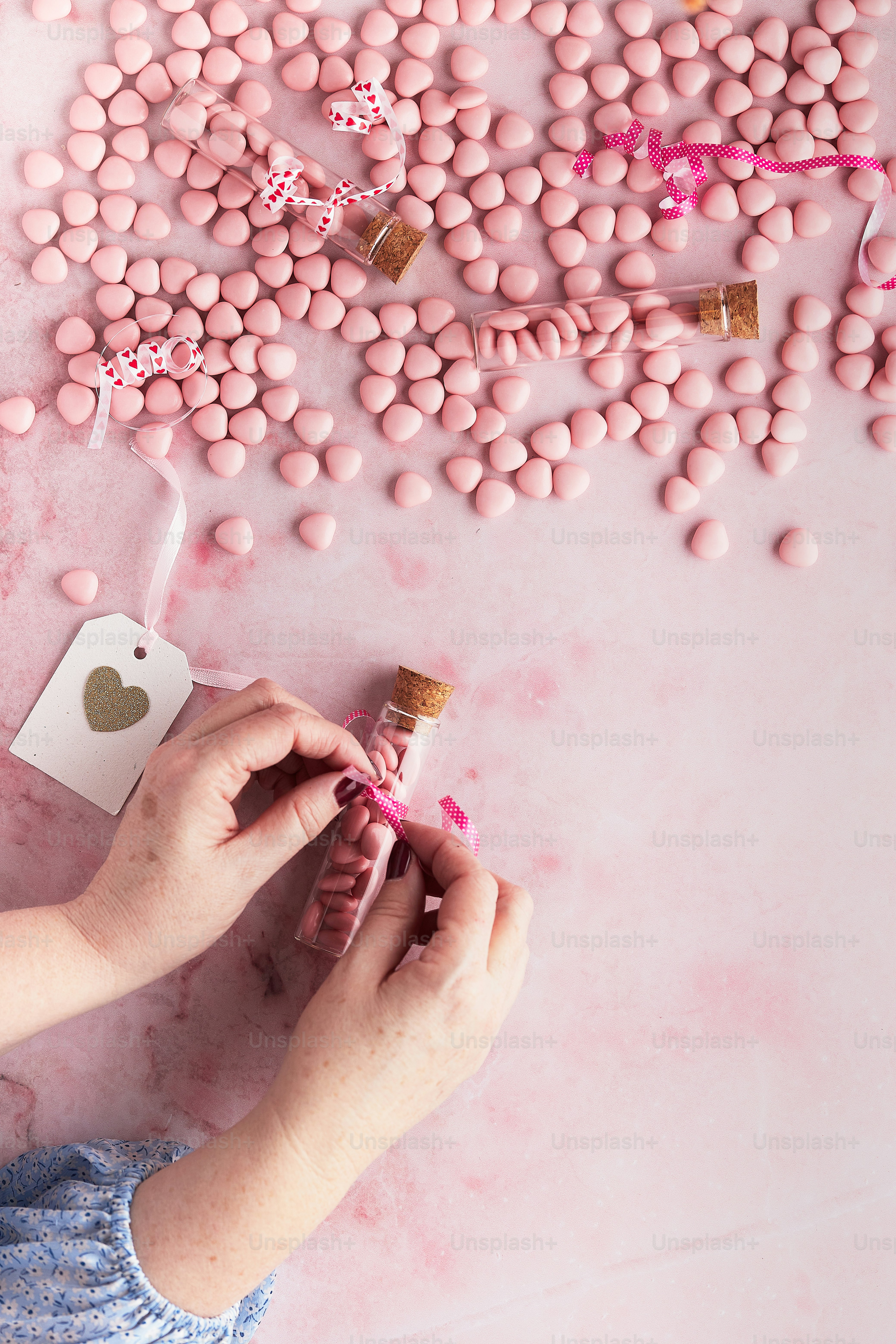a person holding a bottle of pink candy