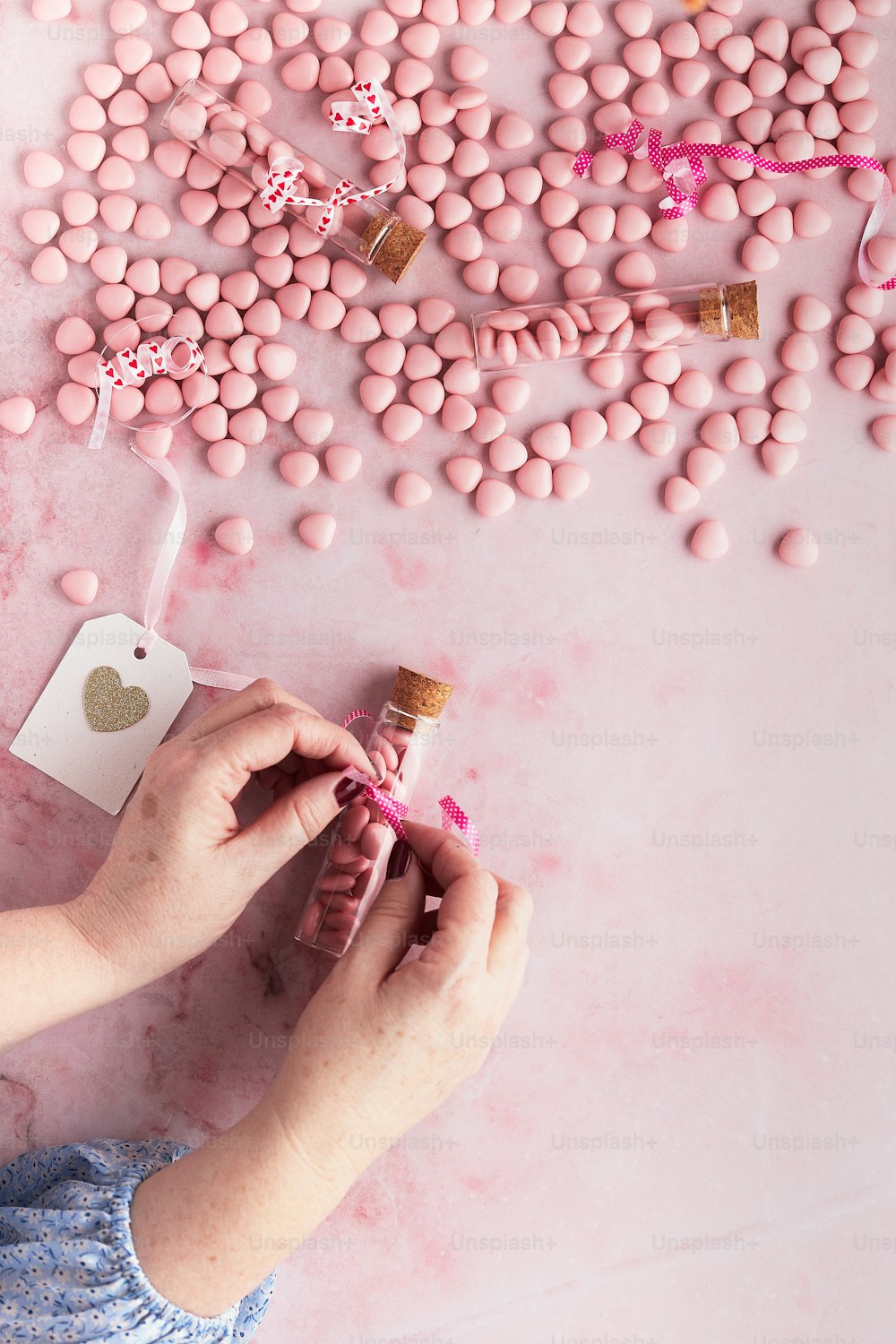 a person holding a bottle of pink candy