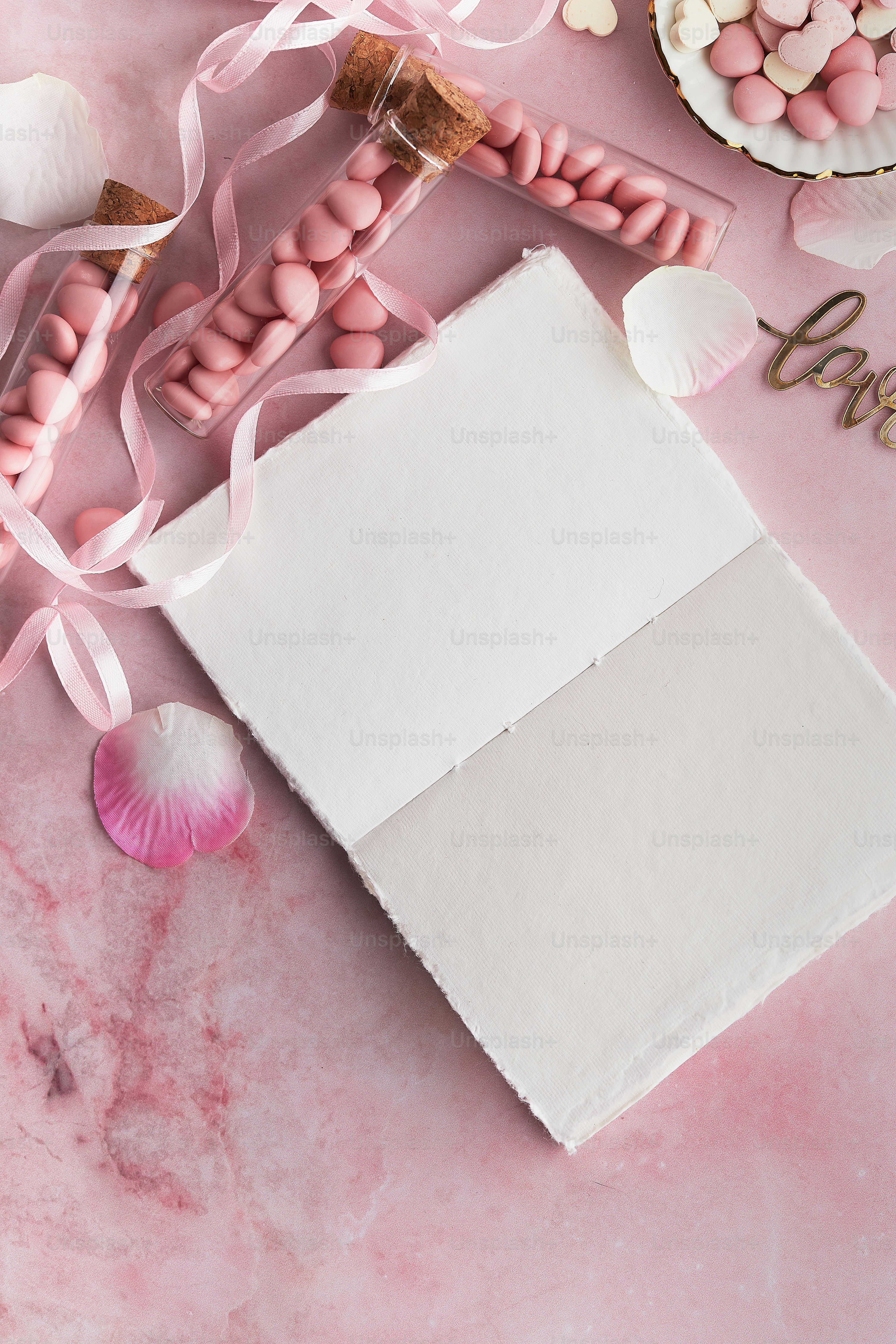 Una mesa cubierta con caramelos rosas y blancos