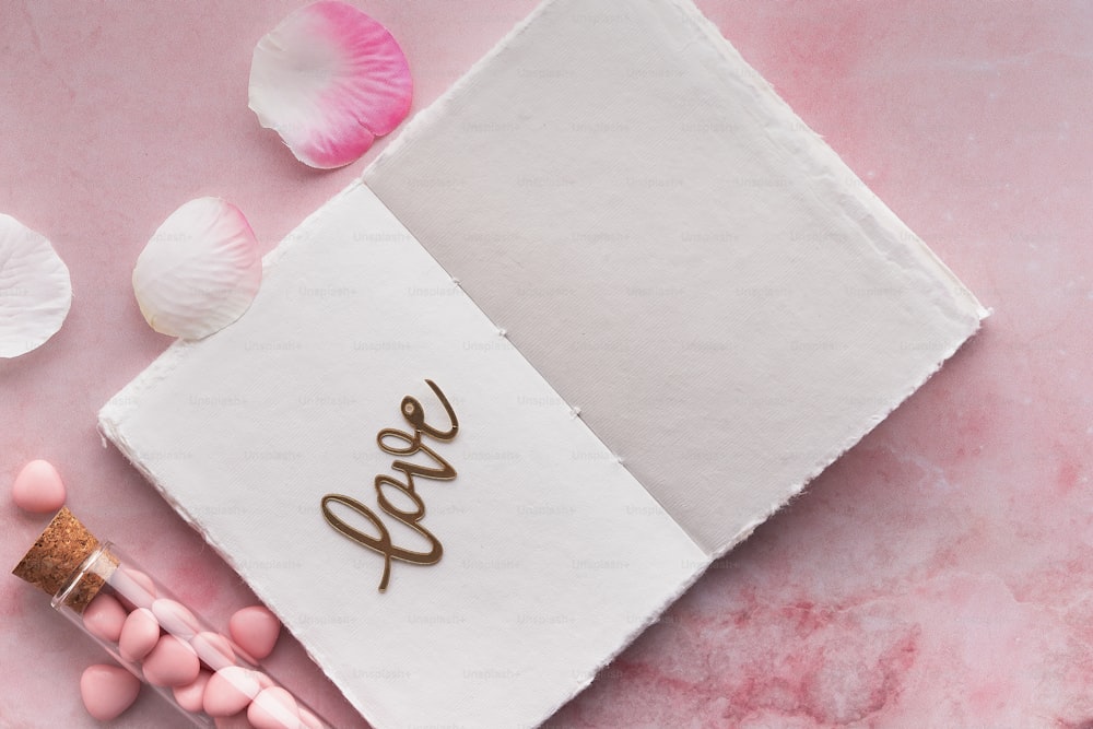 un bloc-notes avec le mot amour écrit dessus à côté de bonbons