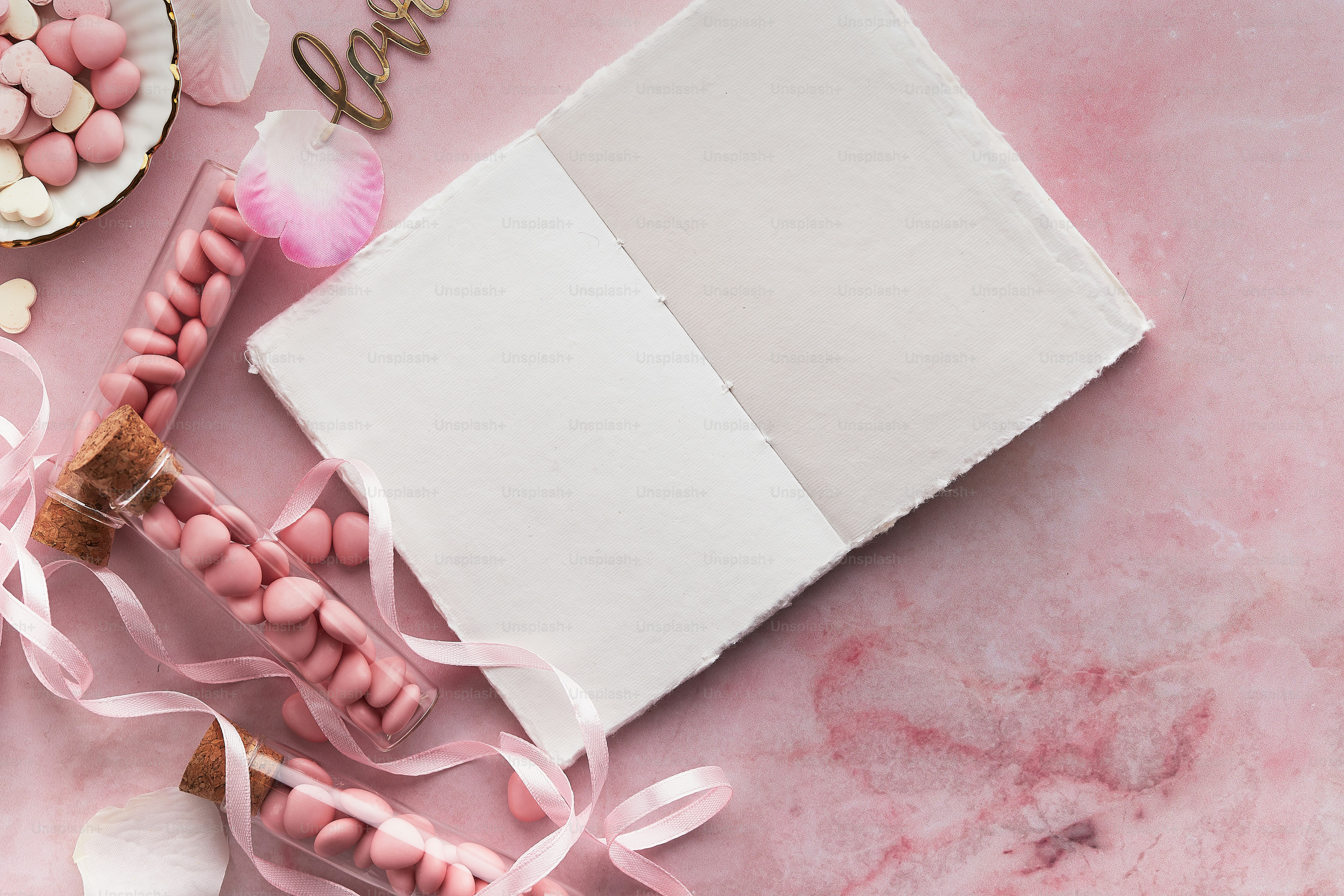 Una mesa rosa cubierta con caramelos rosas y blancos