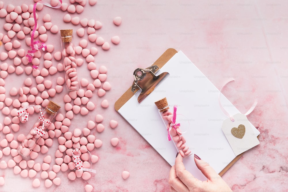 uma pessoa segurando um par de tesouras ao lado de doces cor-de-rosa