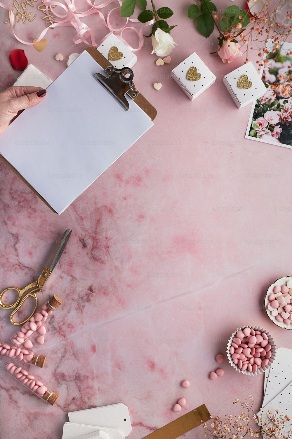 uma mesa rosa coberta com muitos doces e um bloco de notas