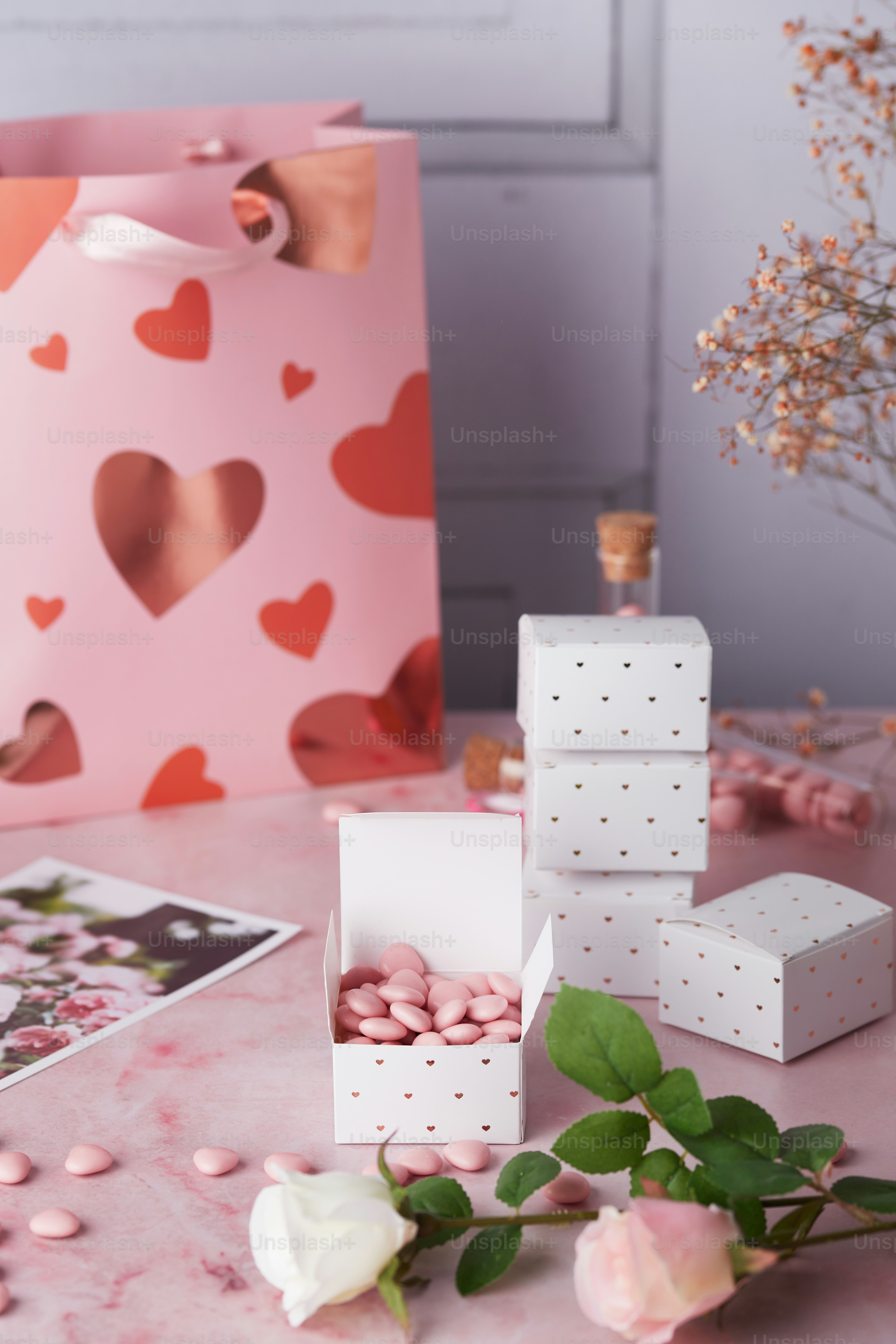 une table rose surmontée de boîtes et de fleurs