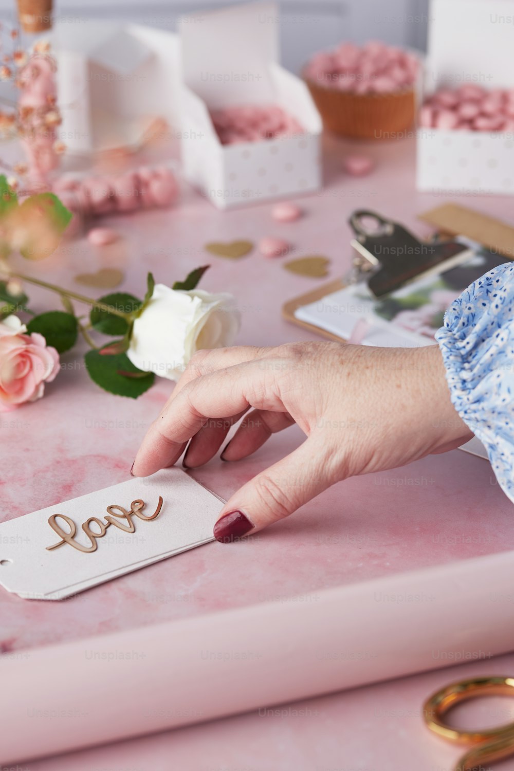 a woman's hand holding a piece of paper with the word love on it